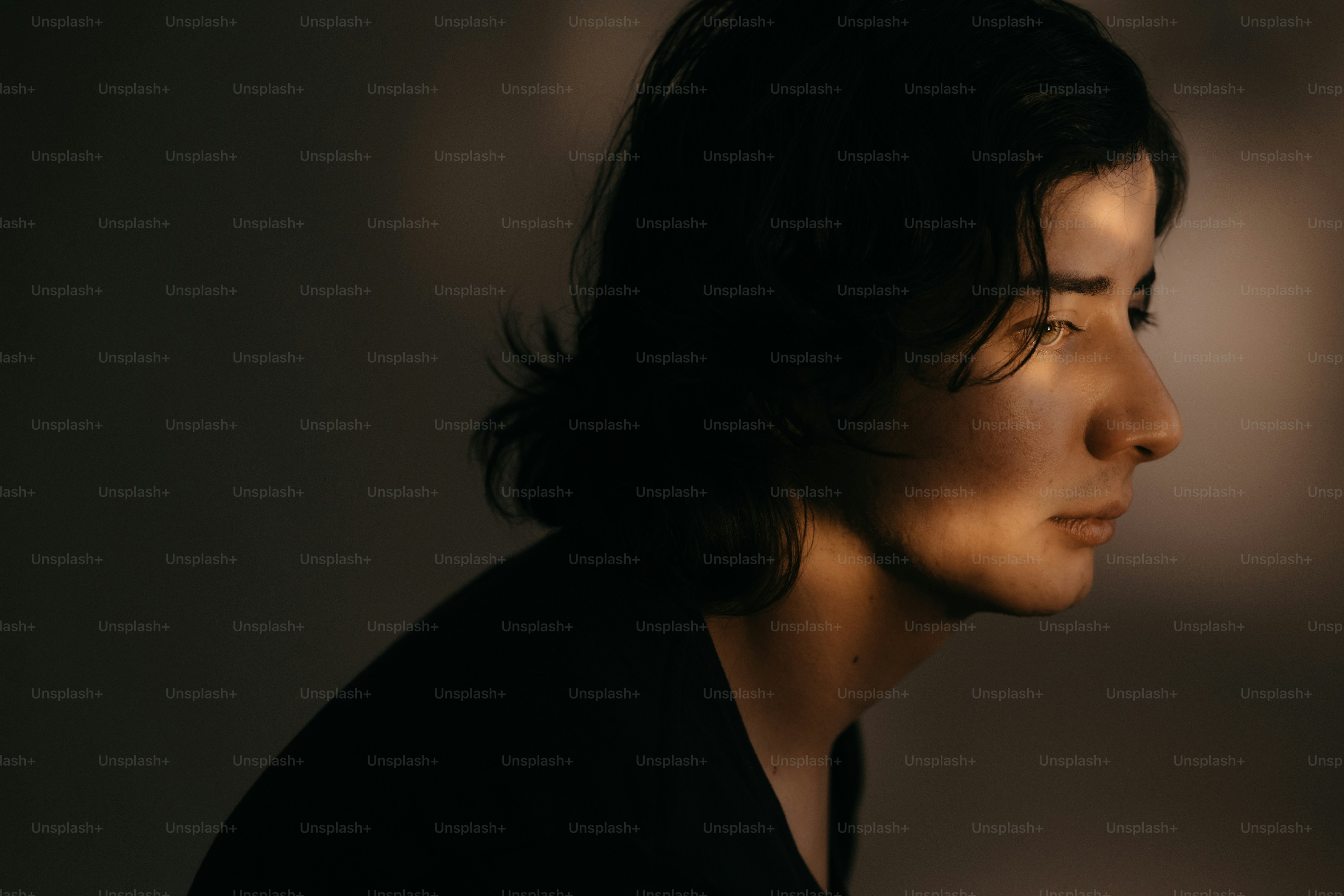 Una persona è in una posa drammatica e ombreggiata.