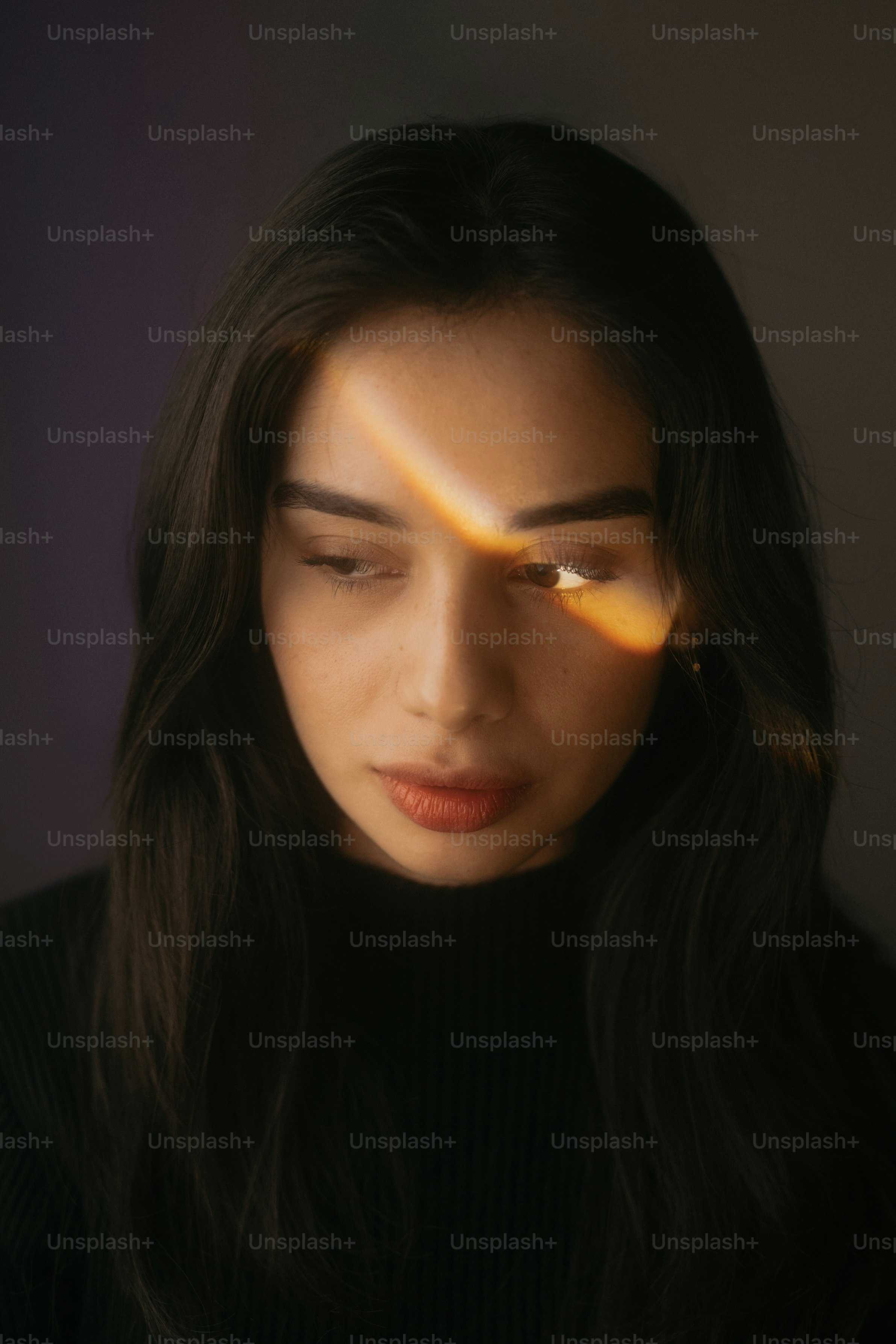 A woman is lit by a ray of sunlight.