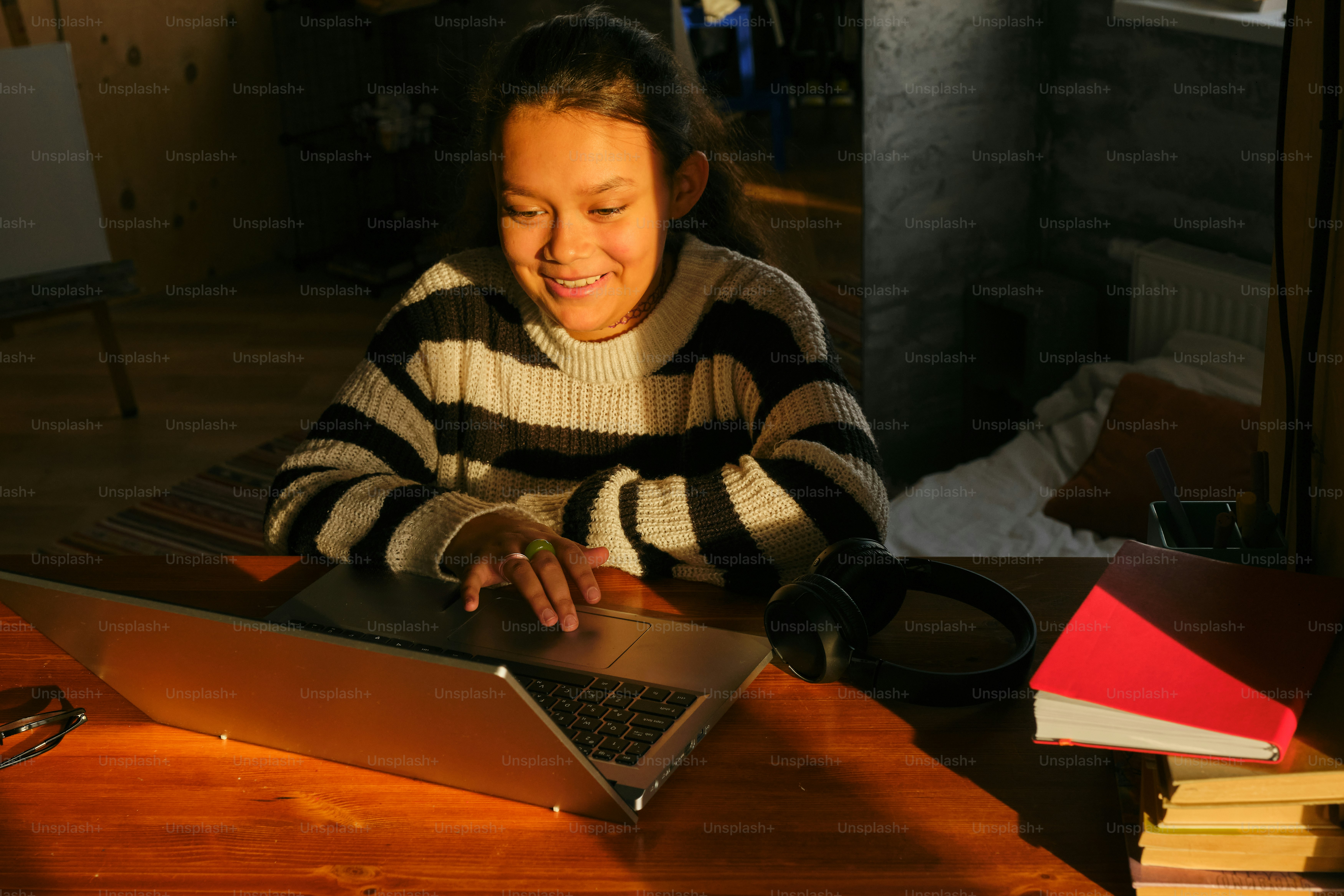 Une femme sourit à son ordinateur portable, travaillant à domicile.