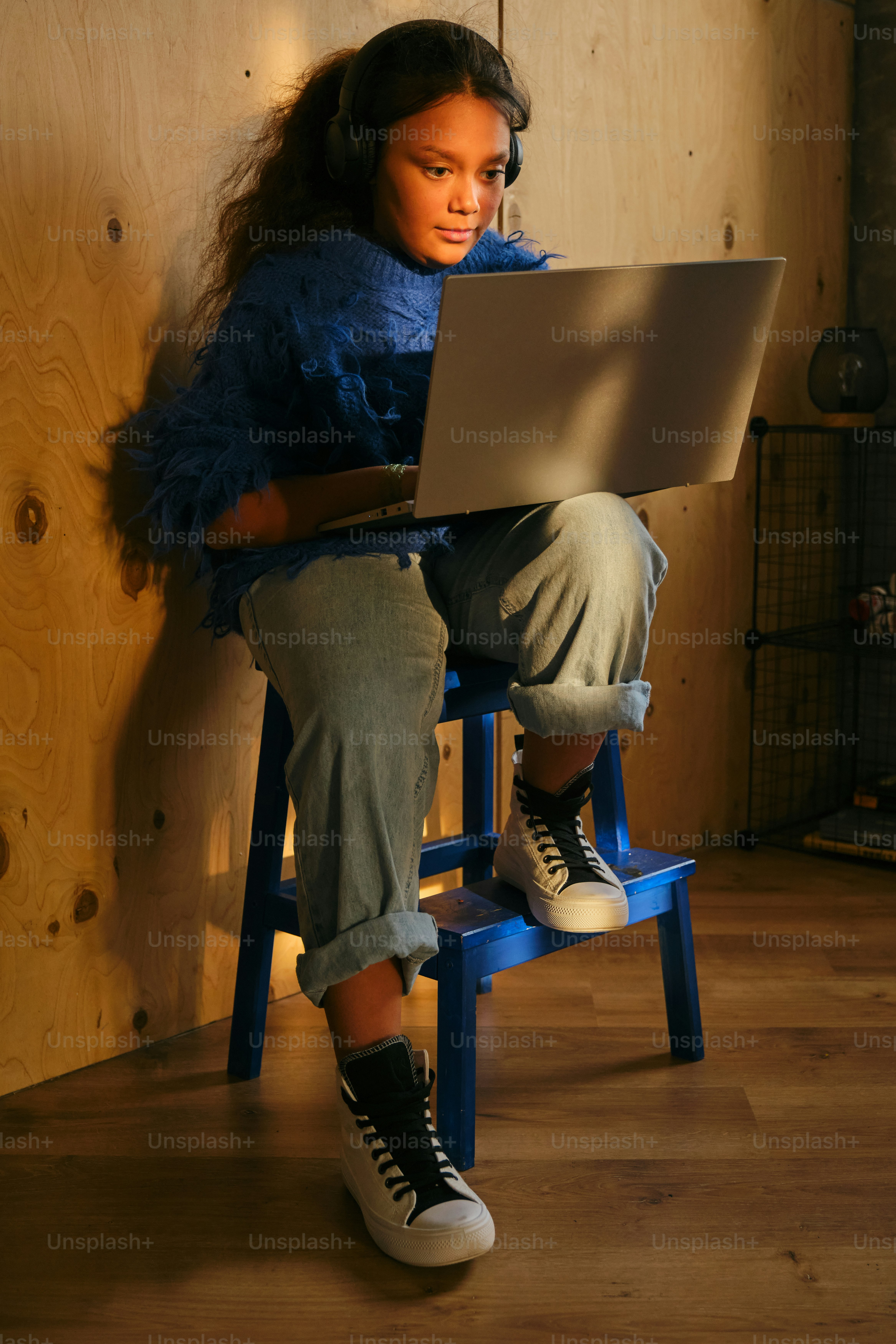 Fille utilisant un ordinateur portable, portant des écouteurs.