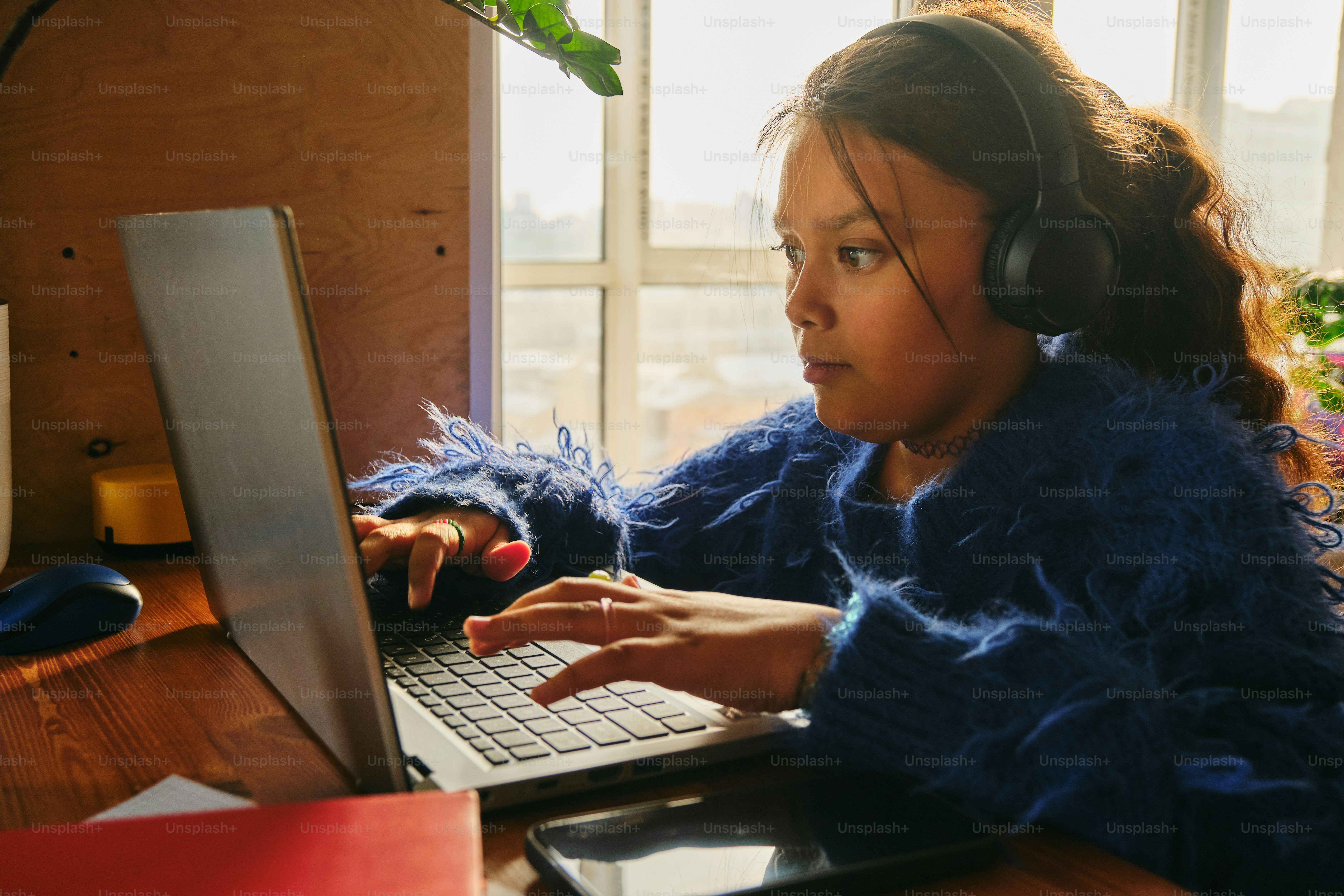 女の子がノートパソコンで勉強しています。