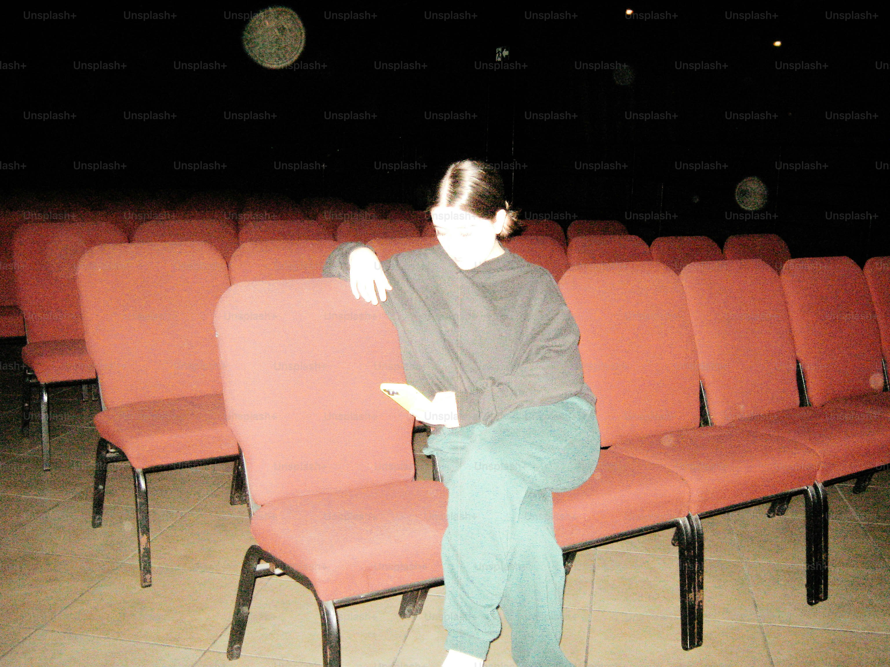 Woman sitting in an empty theater.