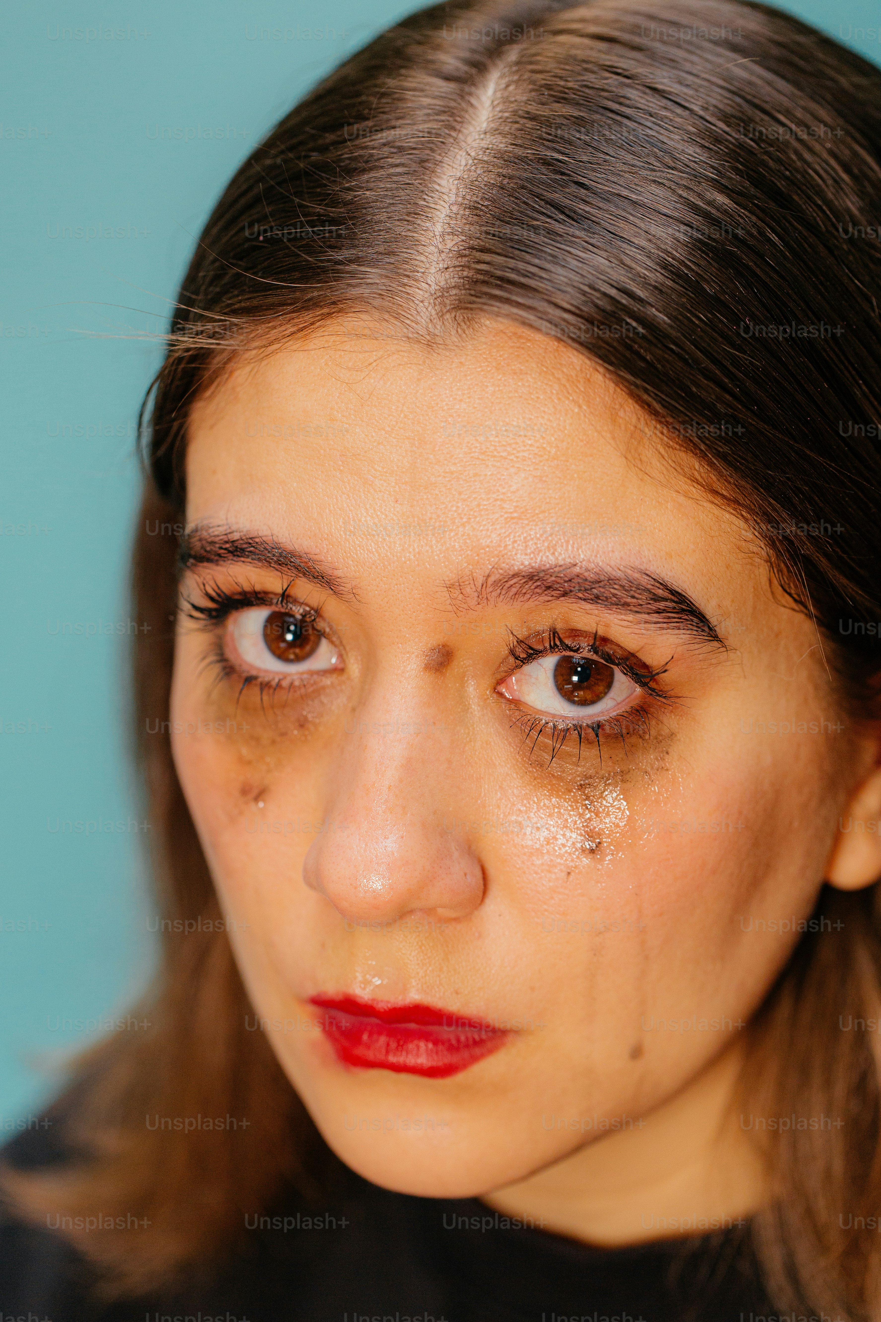 Le lacrime e il trucco sbavato mostrano tristezza e dolore.