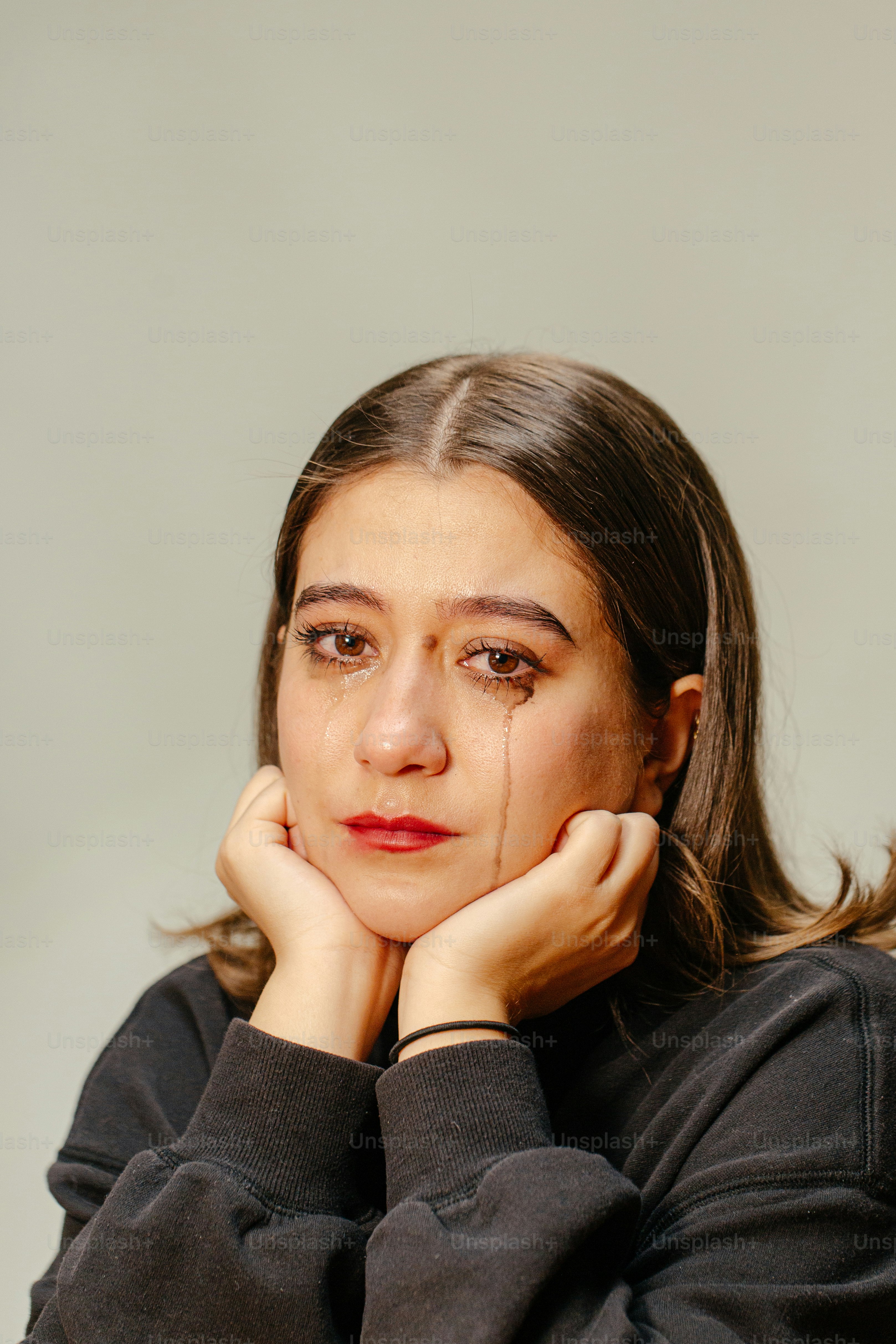 Una donna piange, con il trucco sbavato.