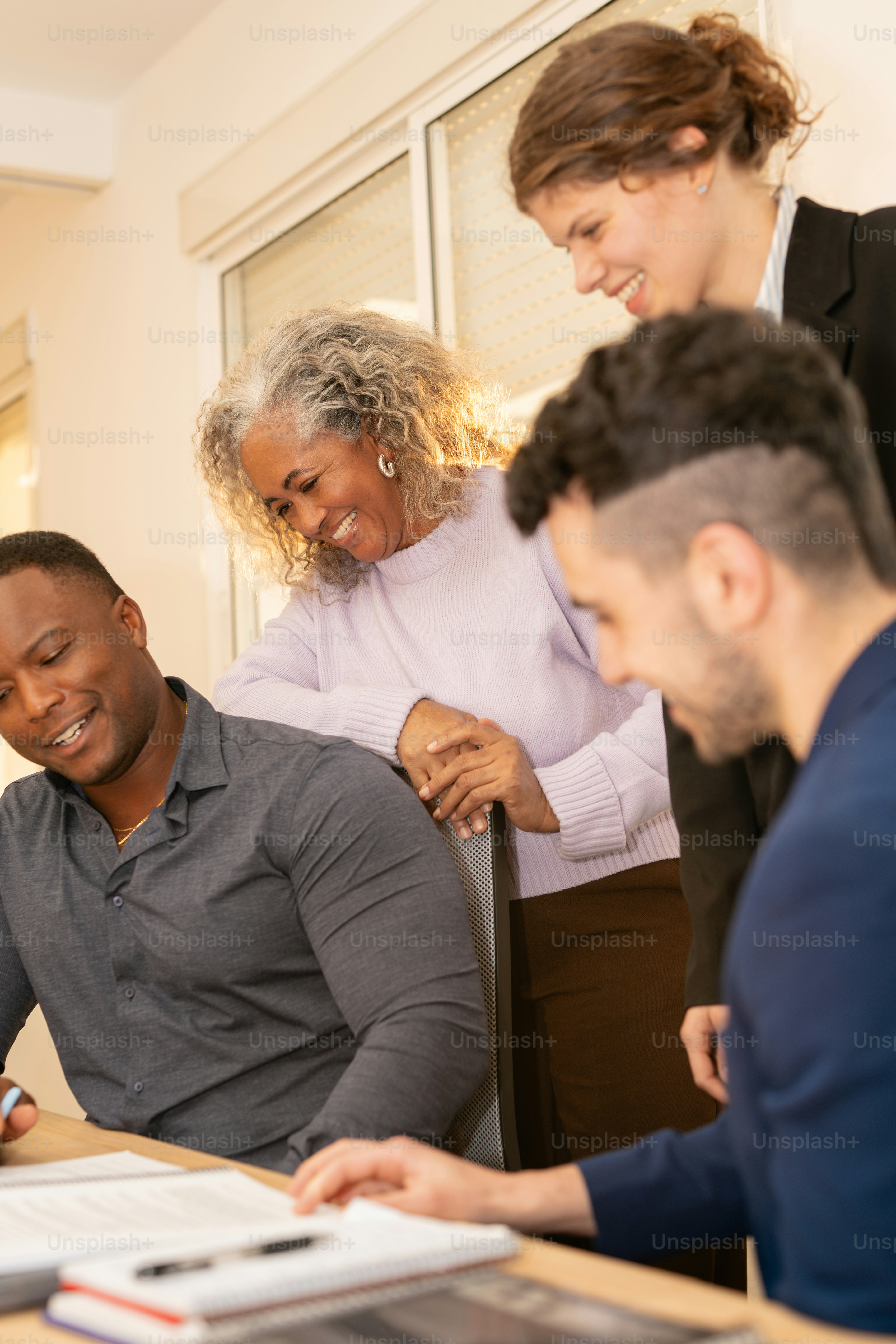 Die Leute lächeln, während sie gemeinsam Dokumente überprüfen.