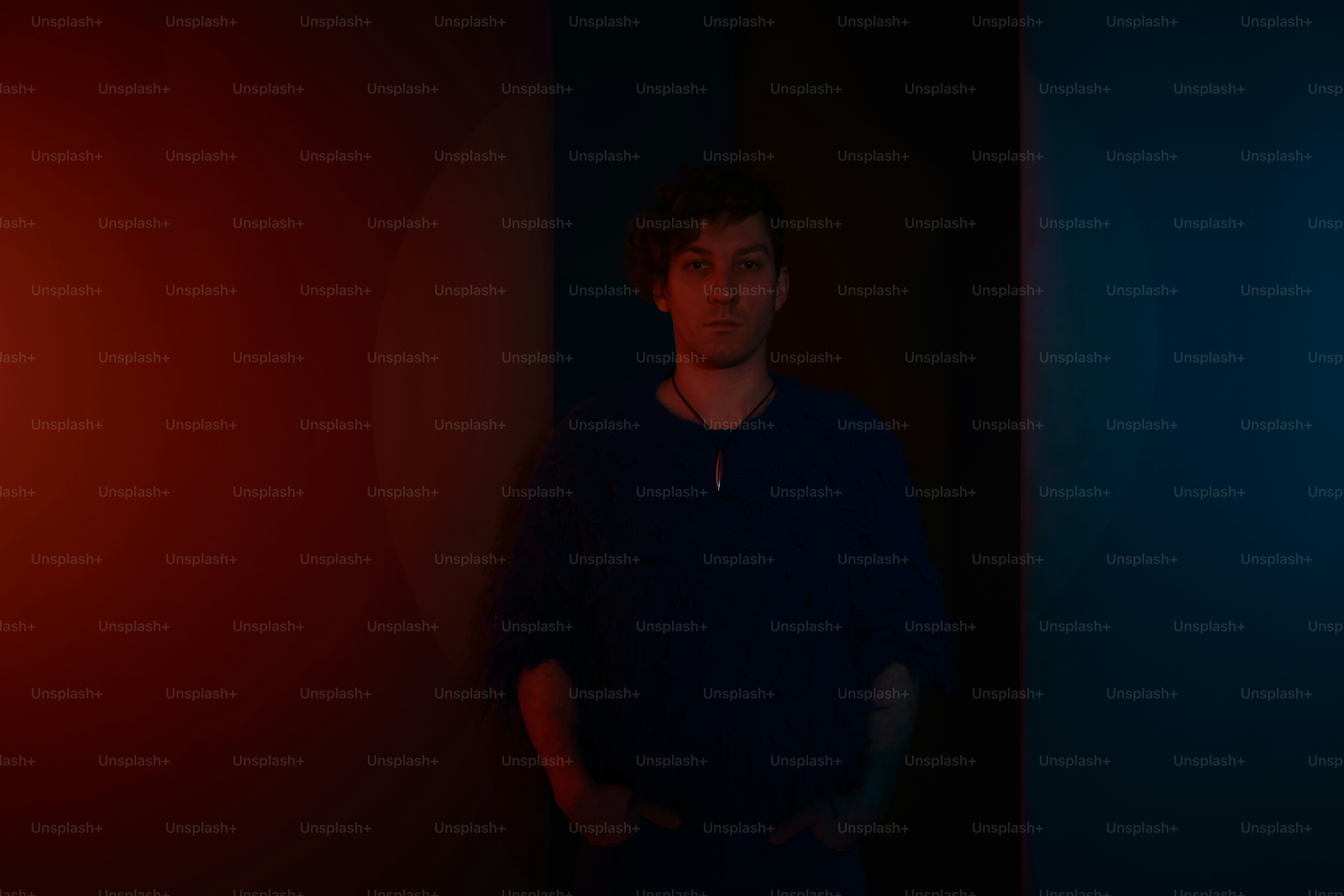 Der Mensch posiert vor kontrastierenden Lichtfarben.