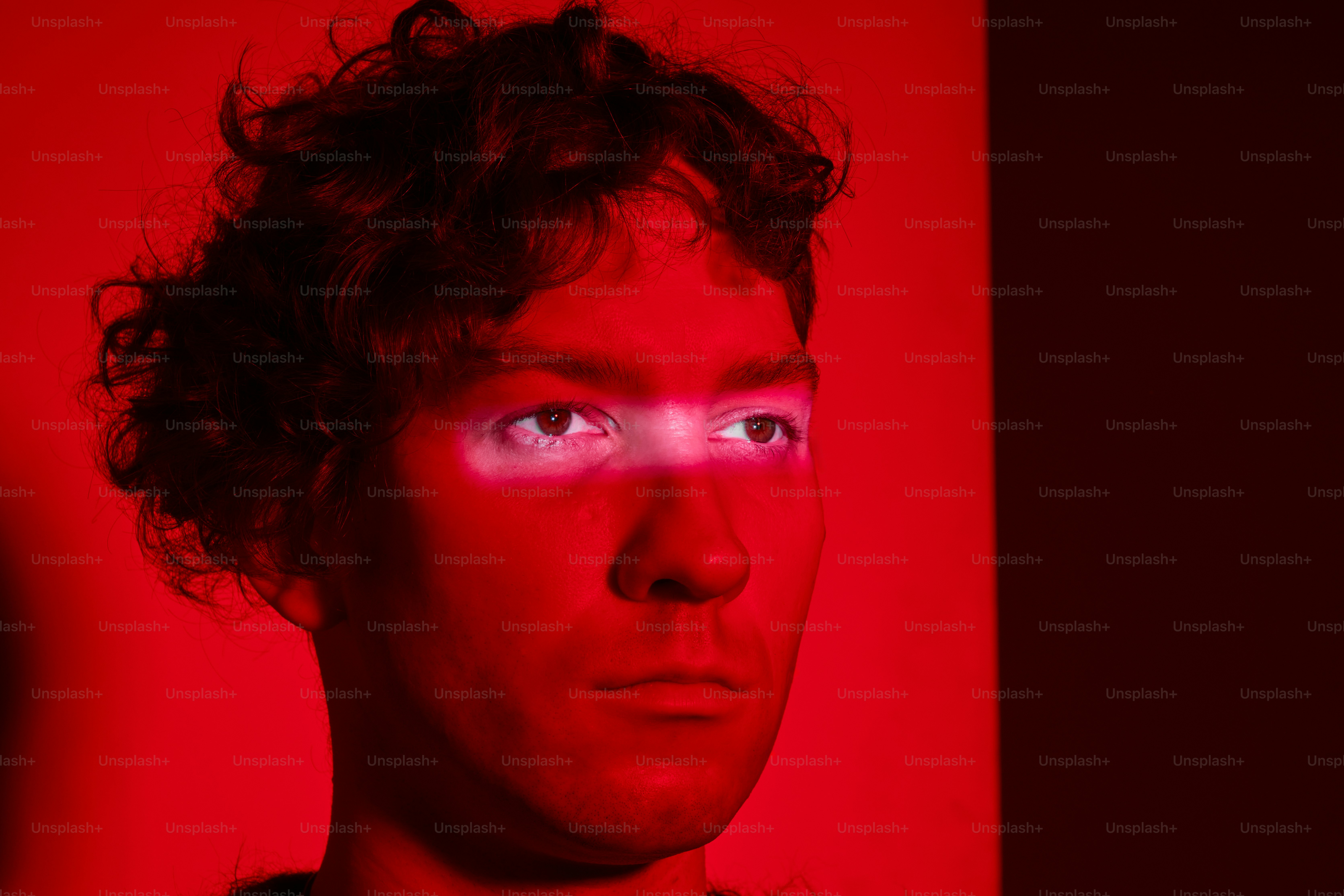 Ein Mann schaut streng unter ein rotes Licht.