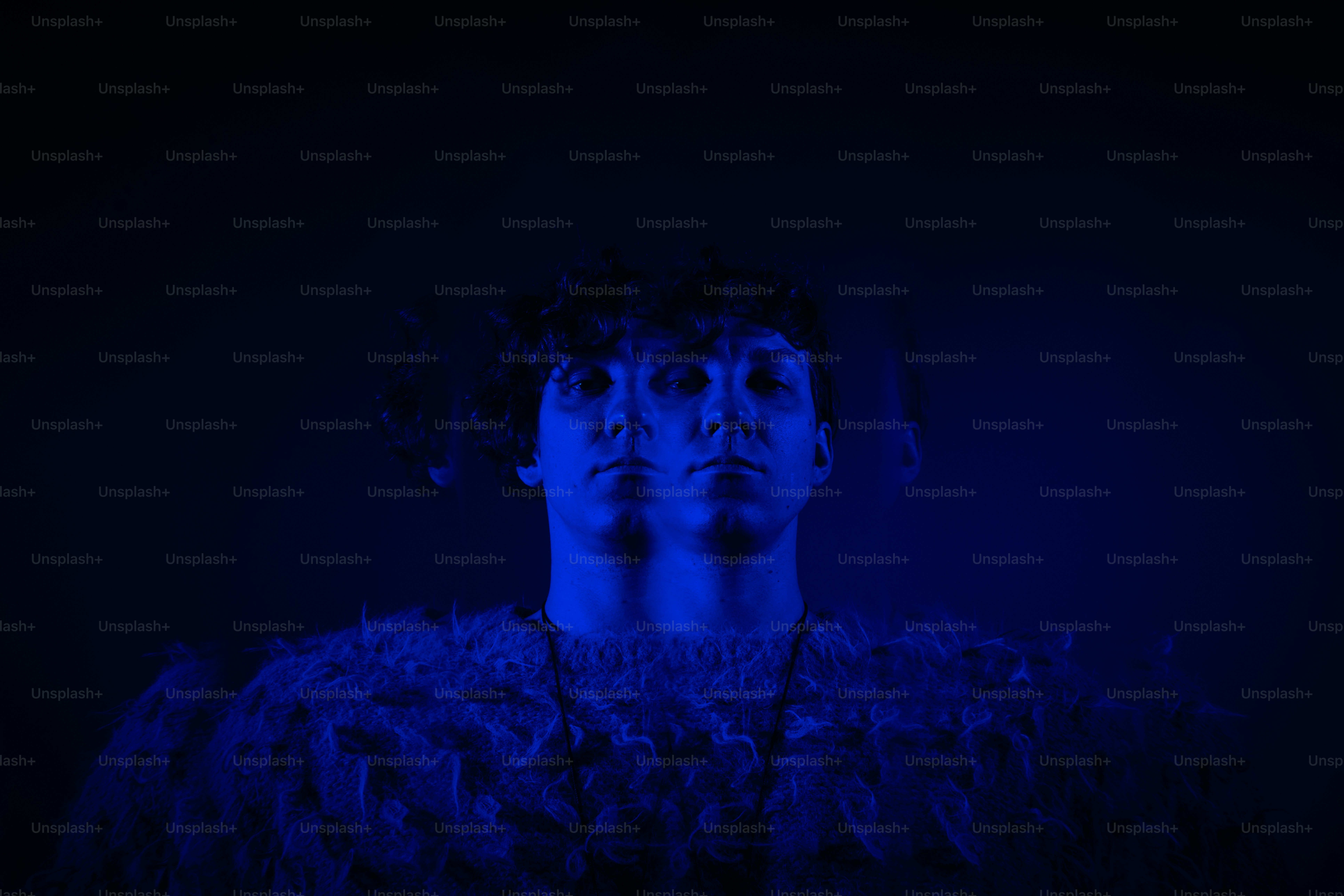 Eine blau beleuchtete Person erscheint doppelt.