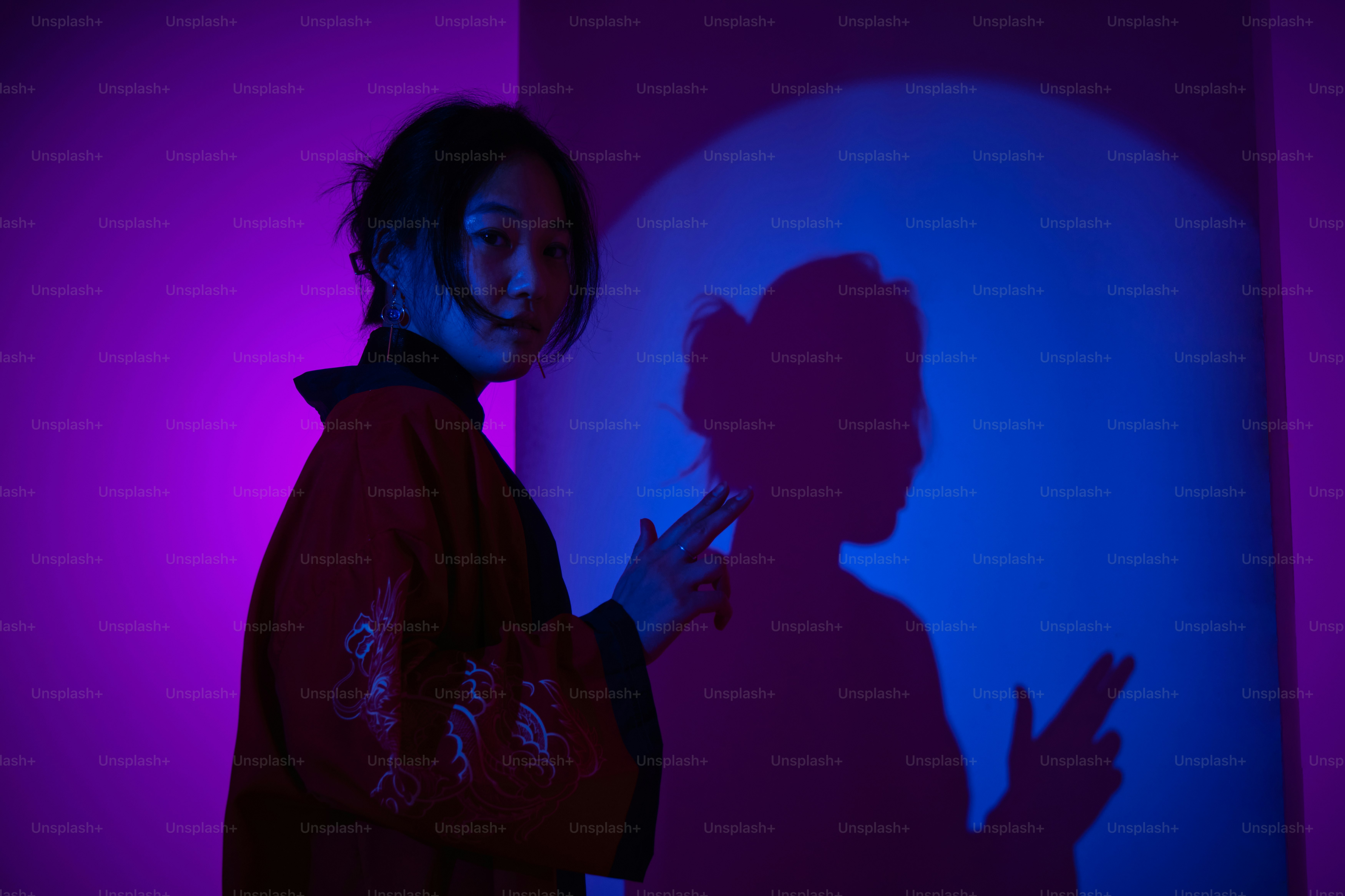 Frau posiert mit ihrem Schatten unter bunten Lichtern.