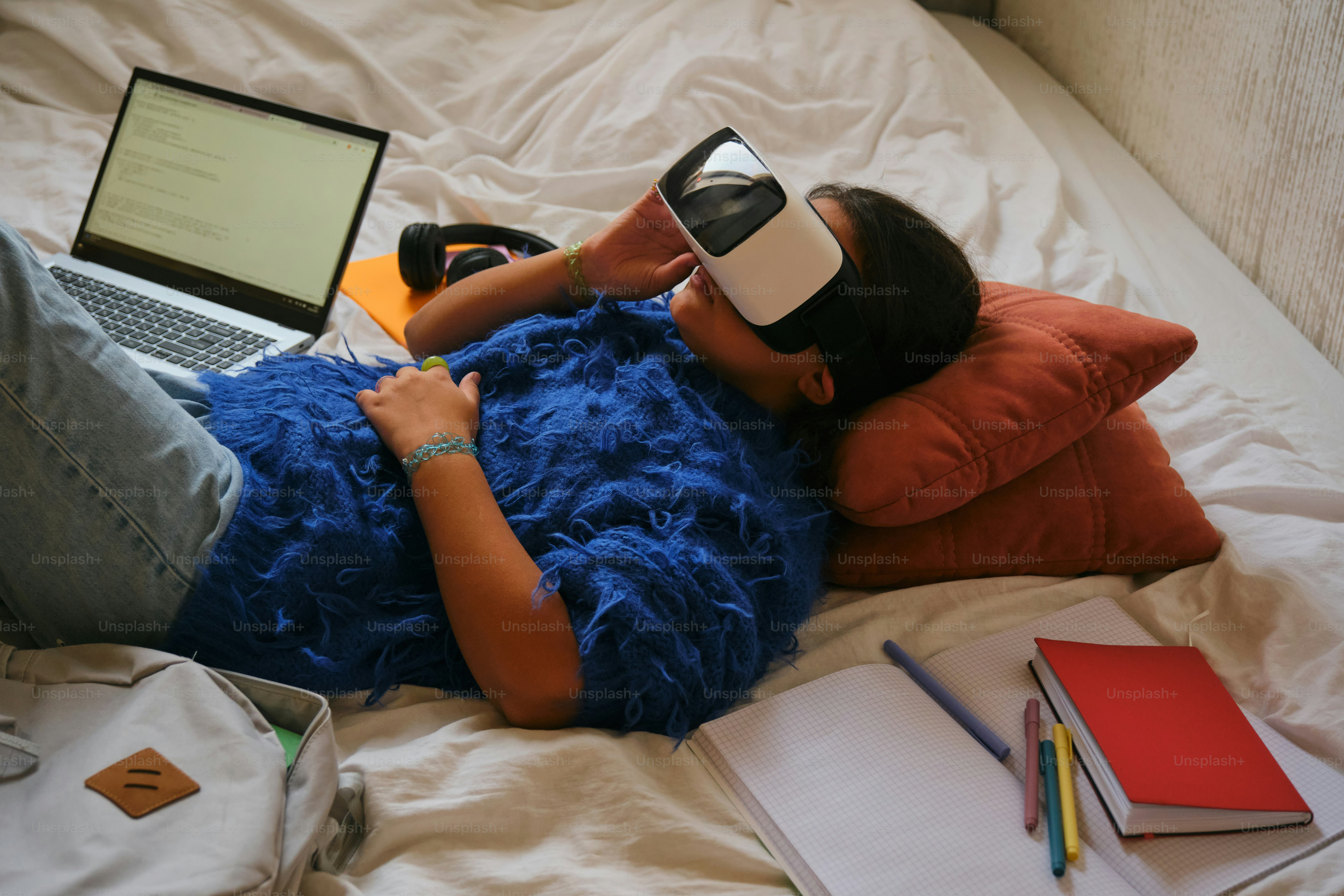 Person wearing a vr headset while lying on bed.
