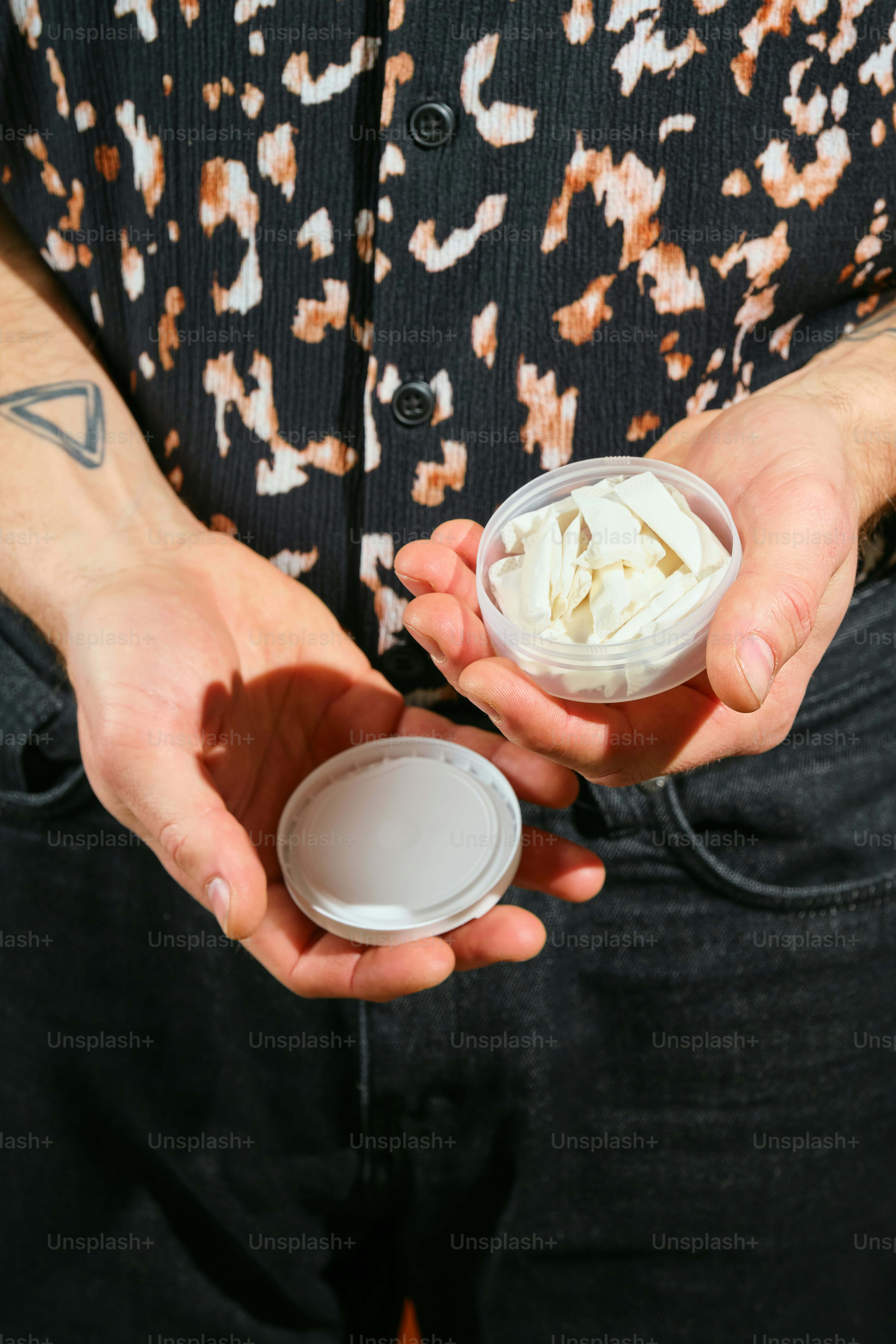Person holds a container of shredded white food.