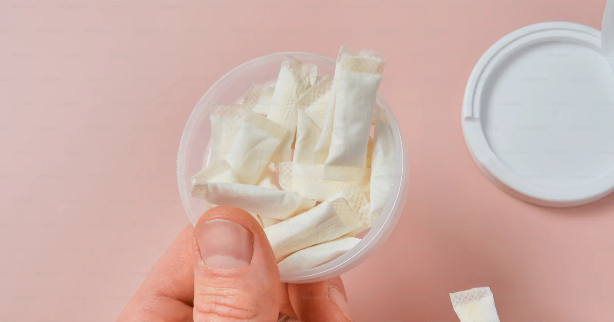 Person holding a container of snus packets. photo – Snus Image on Unsplash