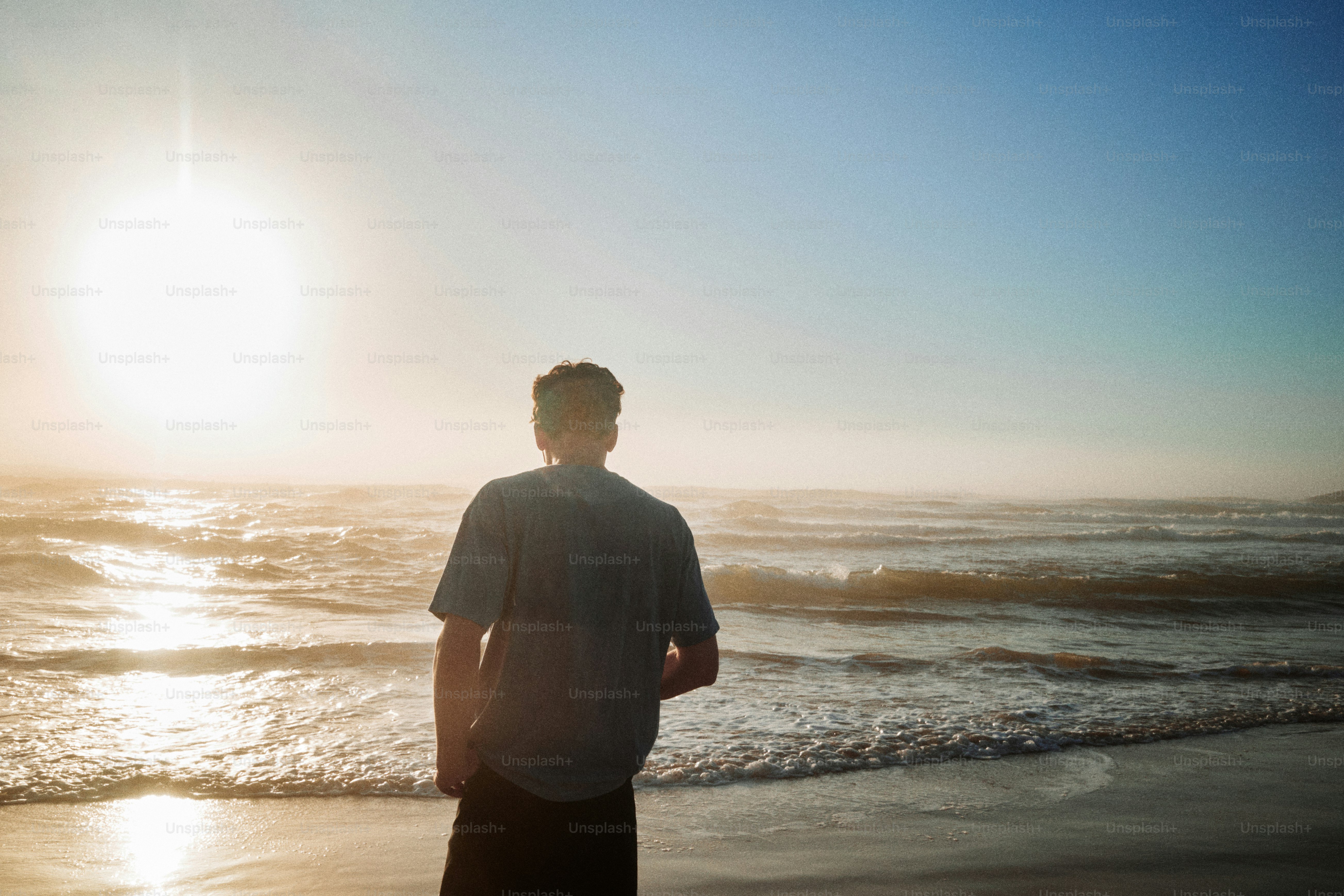 Der Mann beobachtet den Sonnenuntergang über dem Meer.