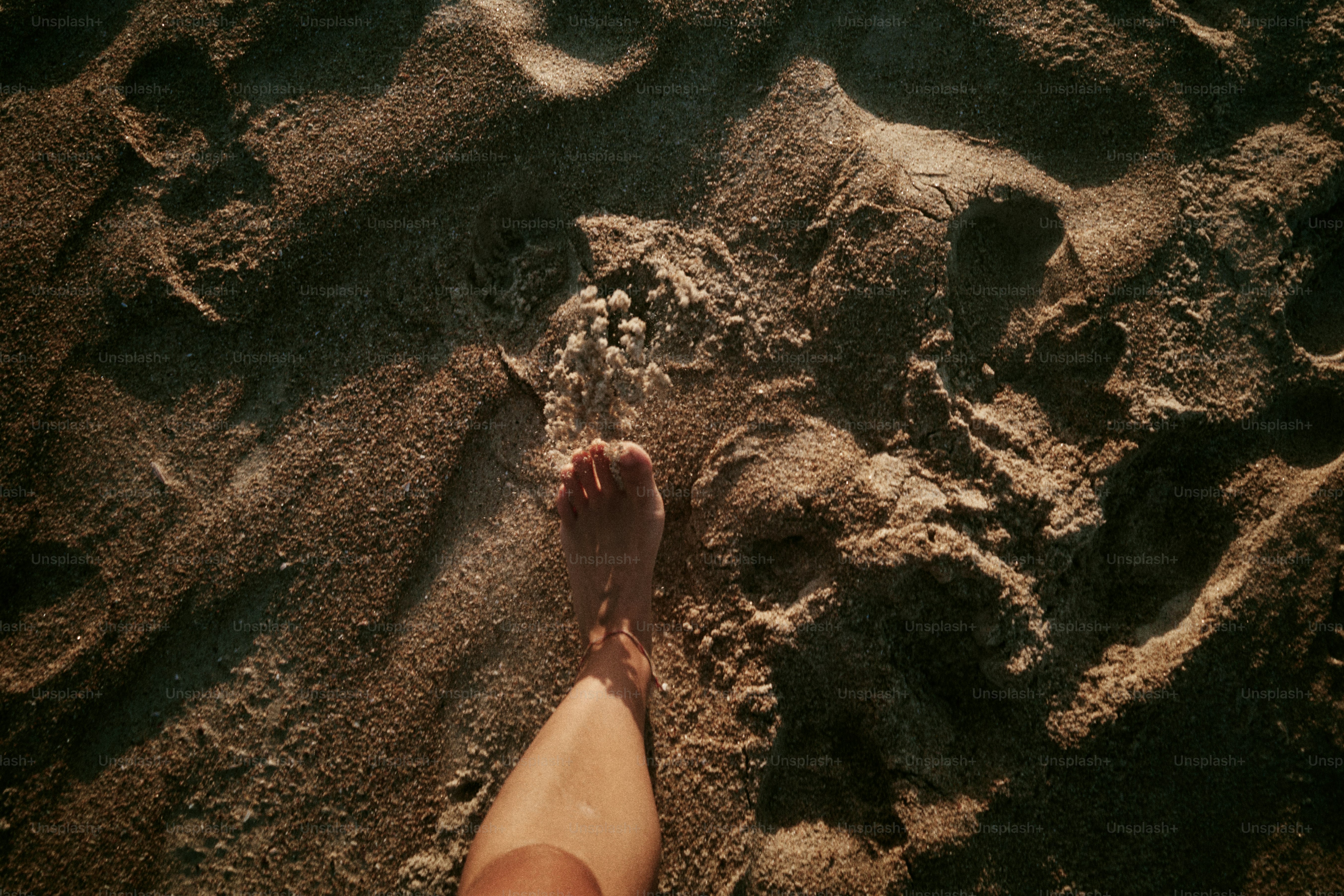 Footprints are visible in the sand on the beach.