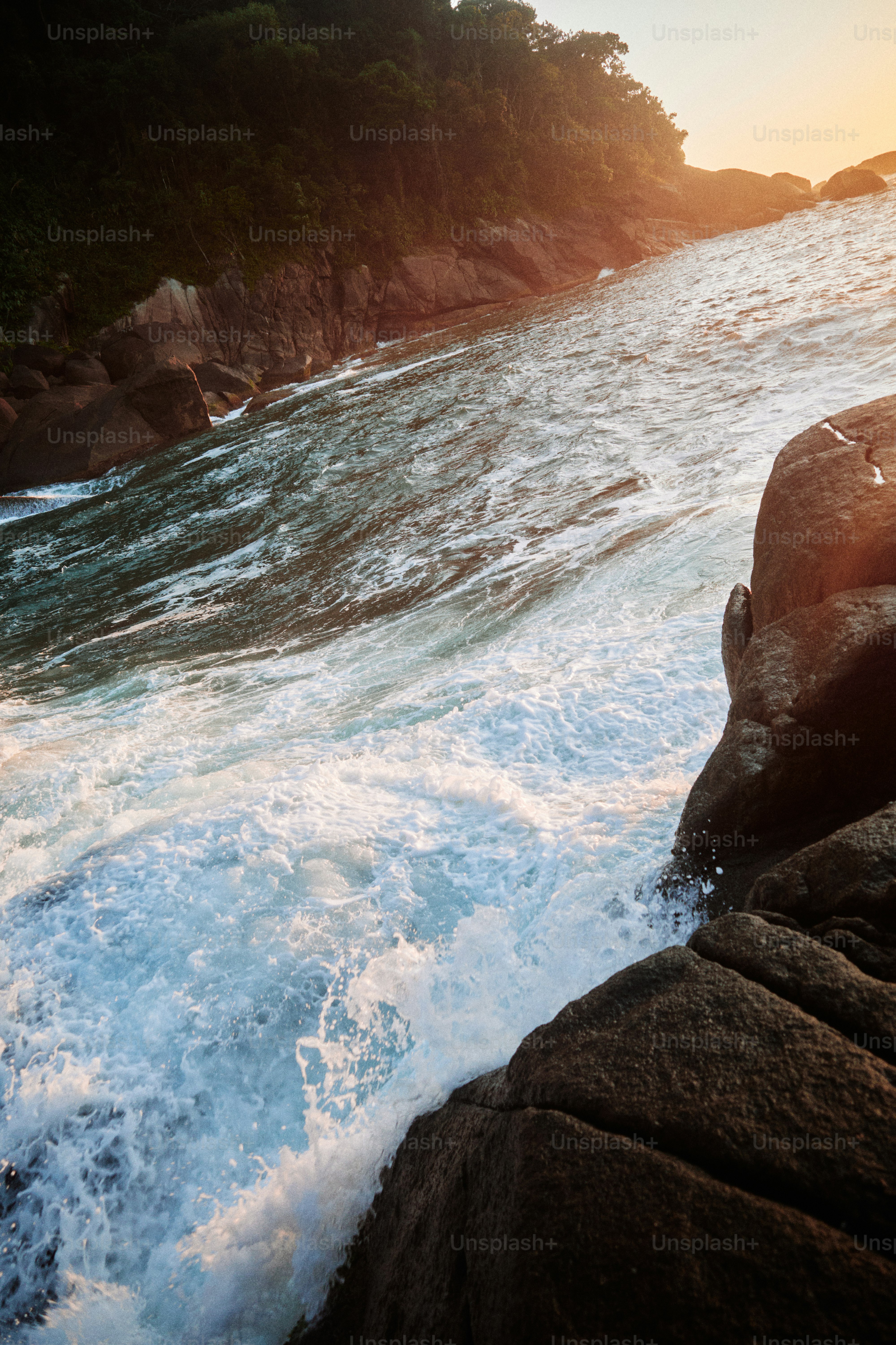 Wellen schlagen gegen das felsige Ufer.
