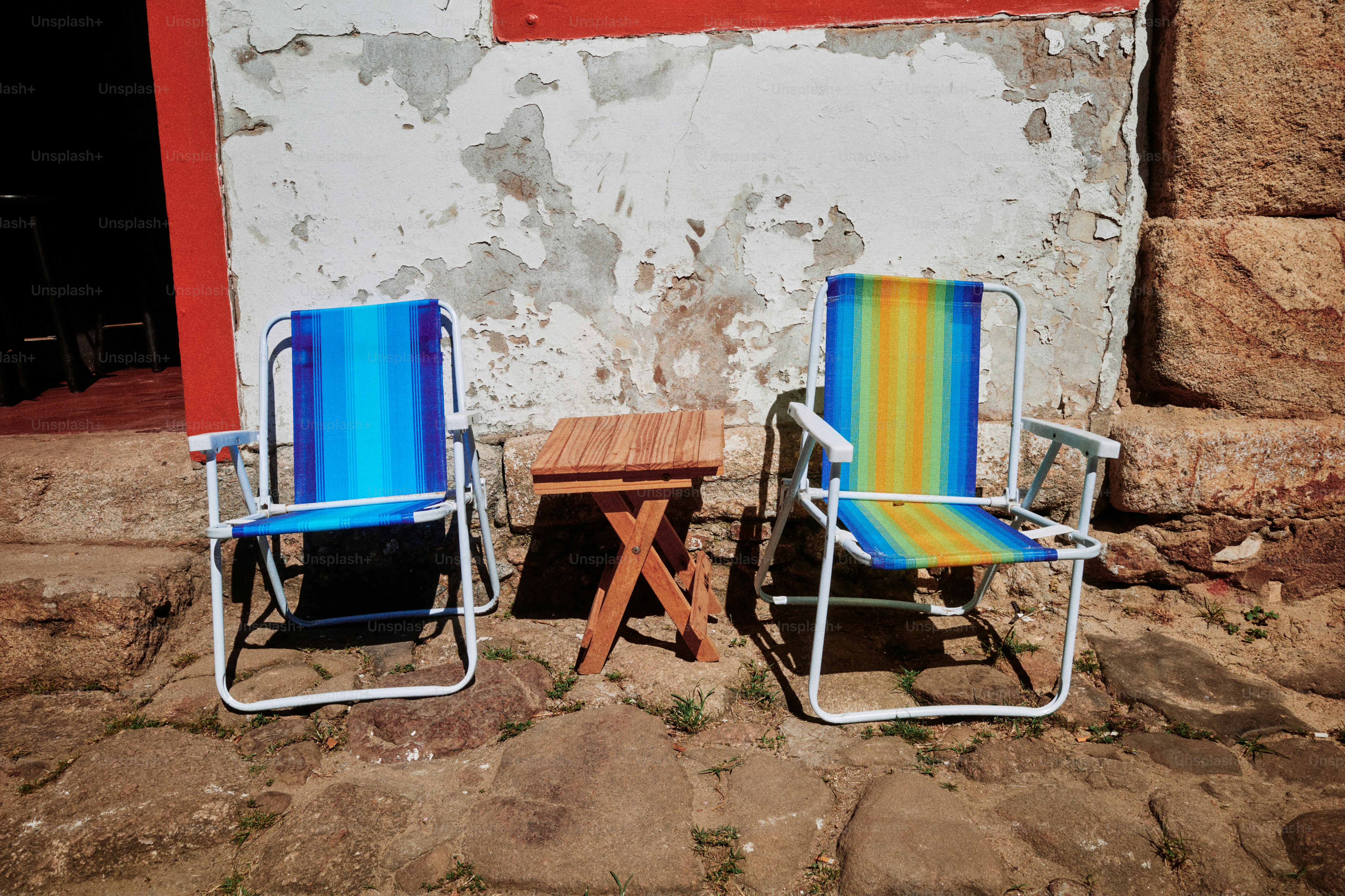 Two beach chairs sit near a small wooden table.
