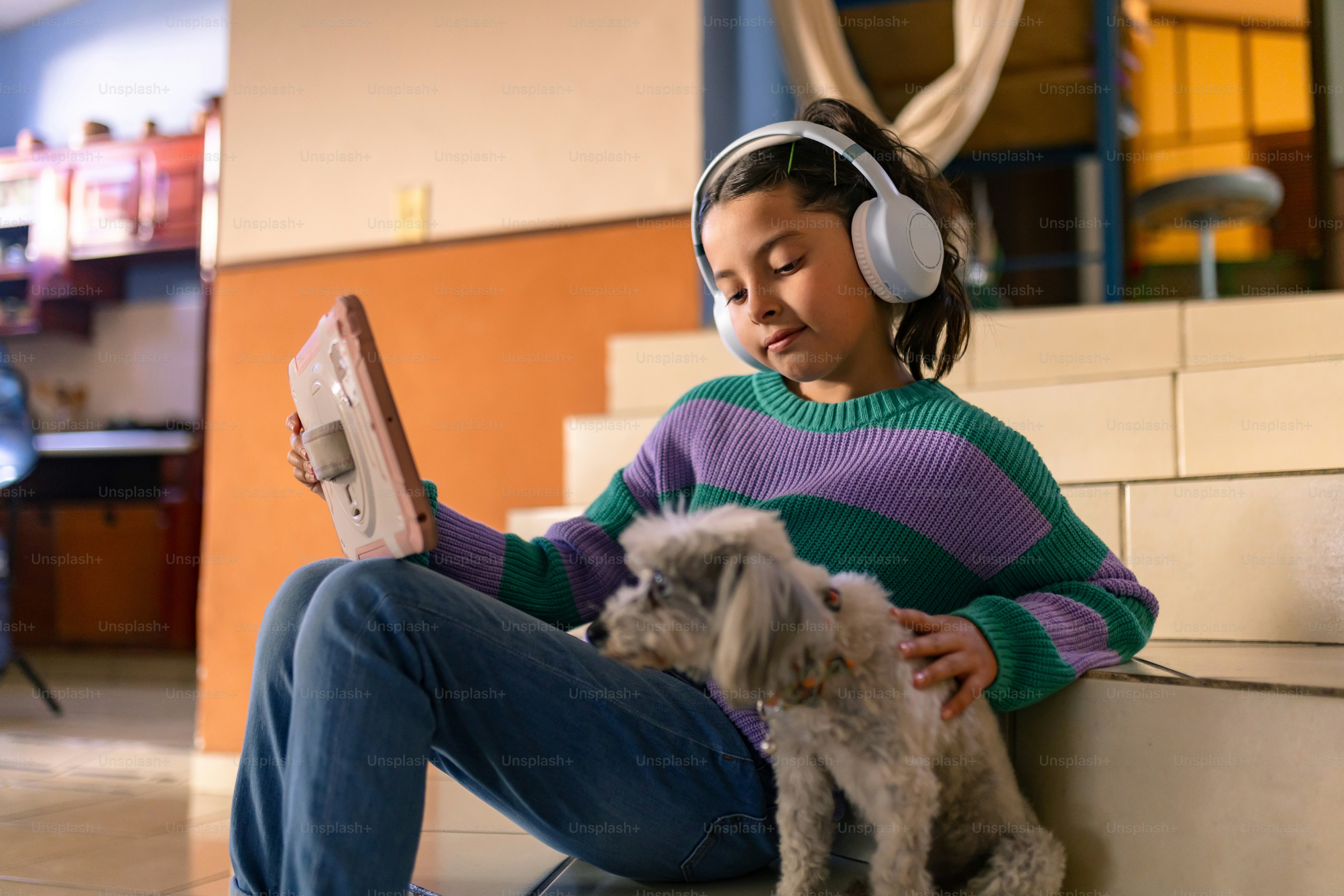 Girl and dog enjoying a tablet on stairs.