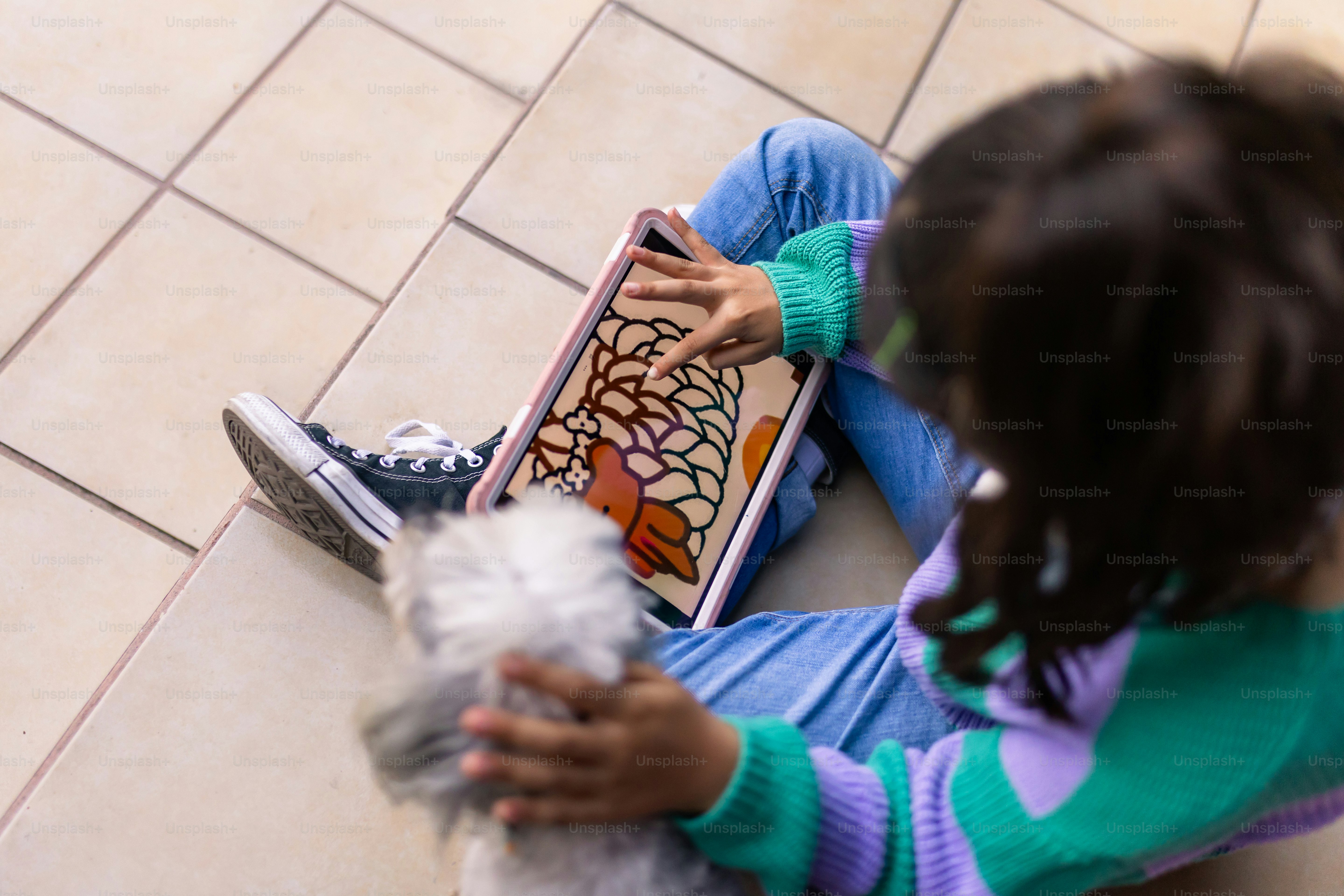 A child is playing a game on a tablet.