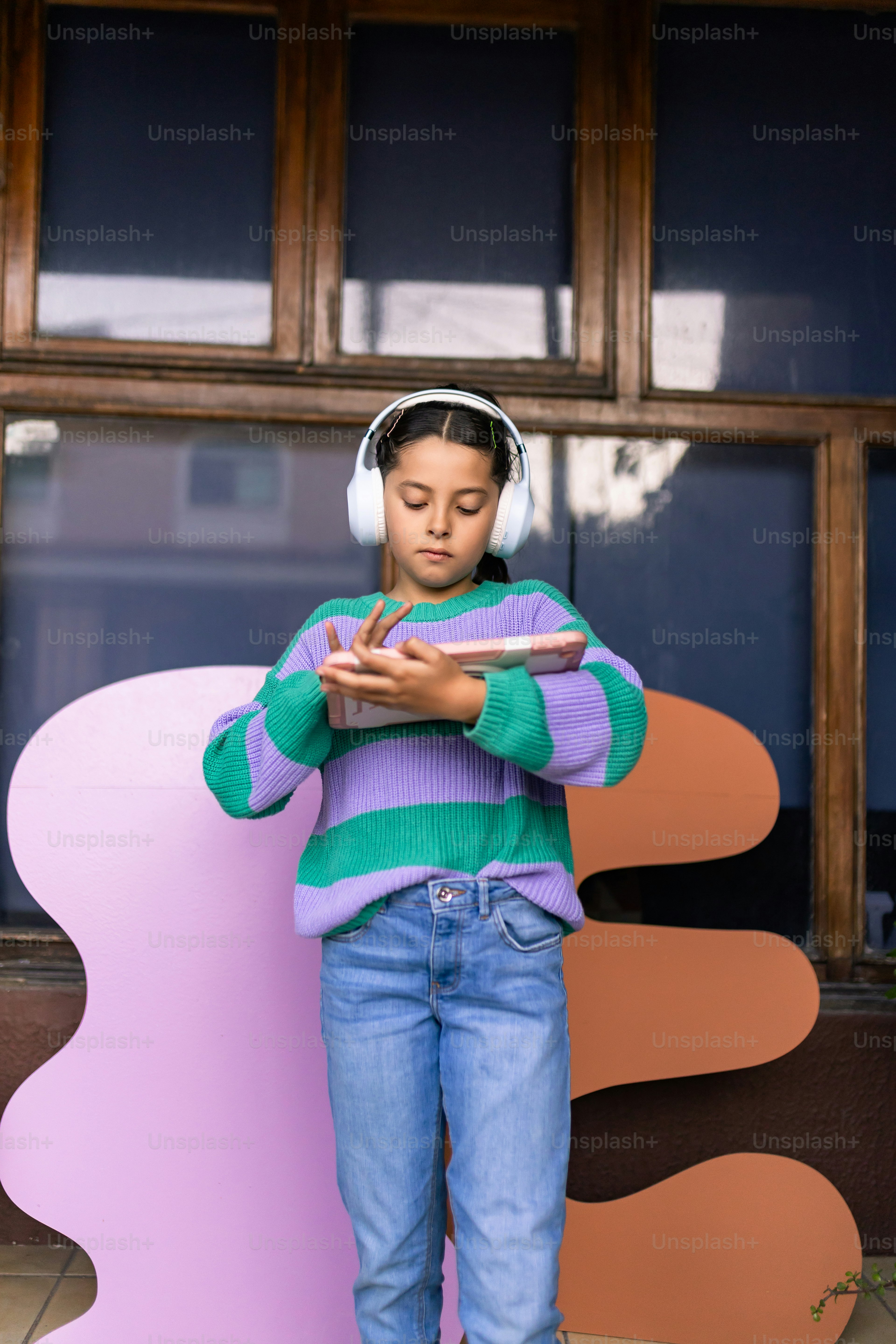 Girl with headphones looking at a tablet.