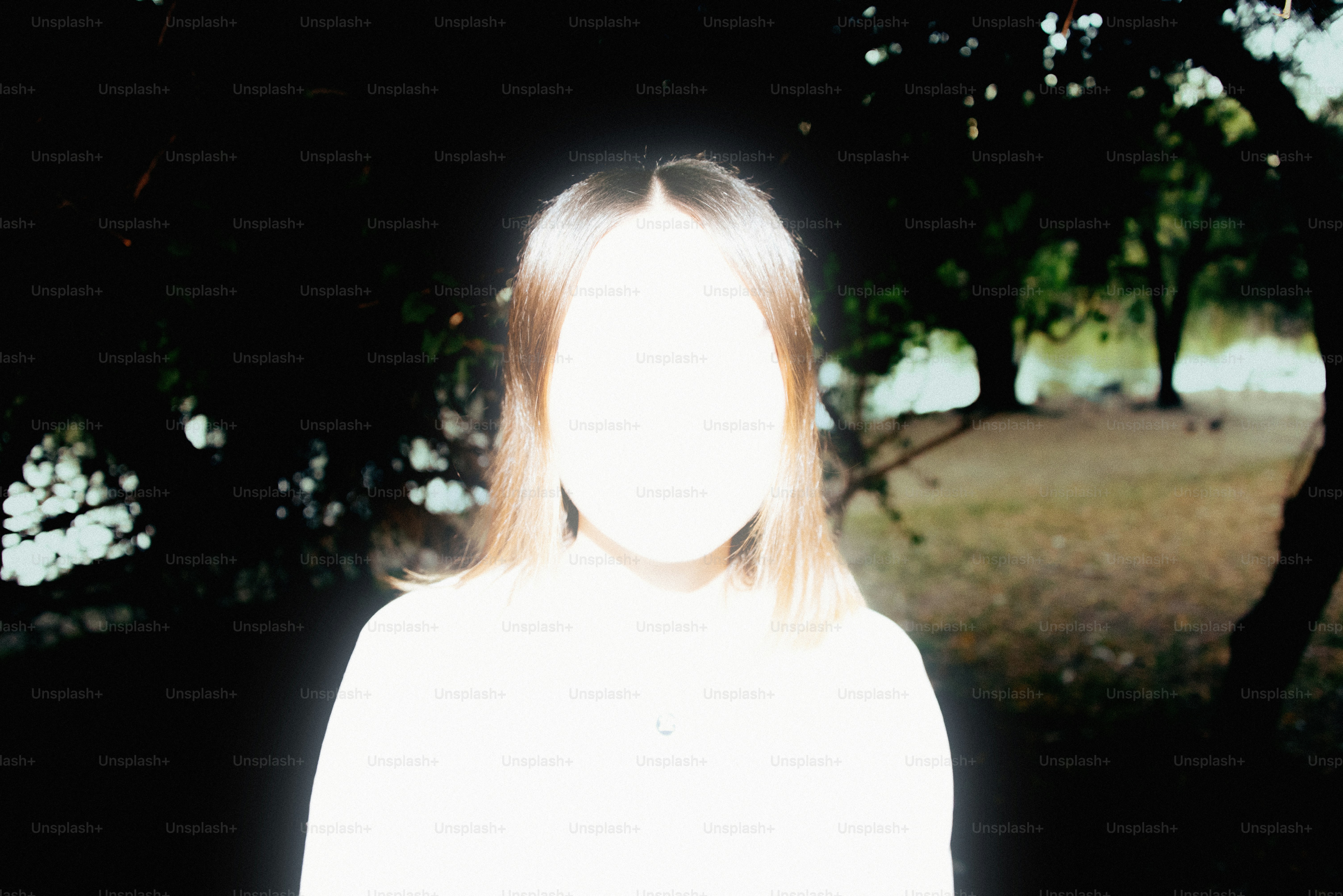 Woman's face is completely blurred, surrounded by nature.