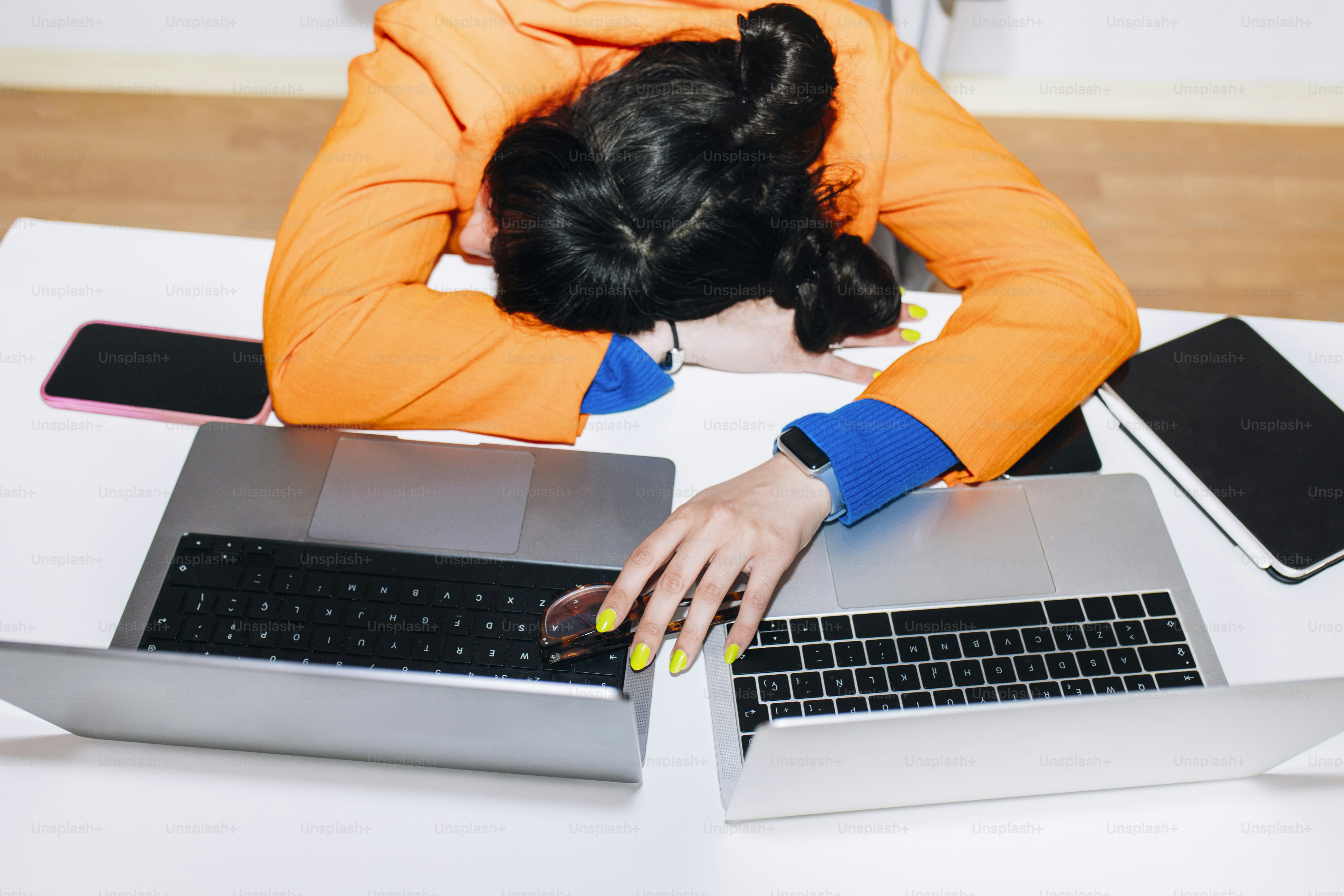 Woman exhausted, slumped on her desk.