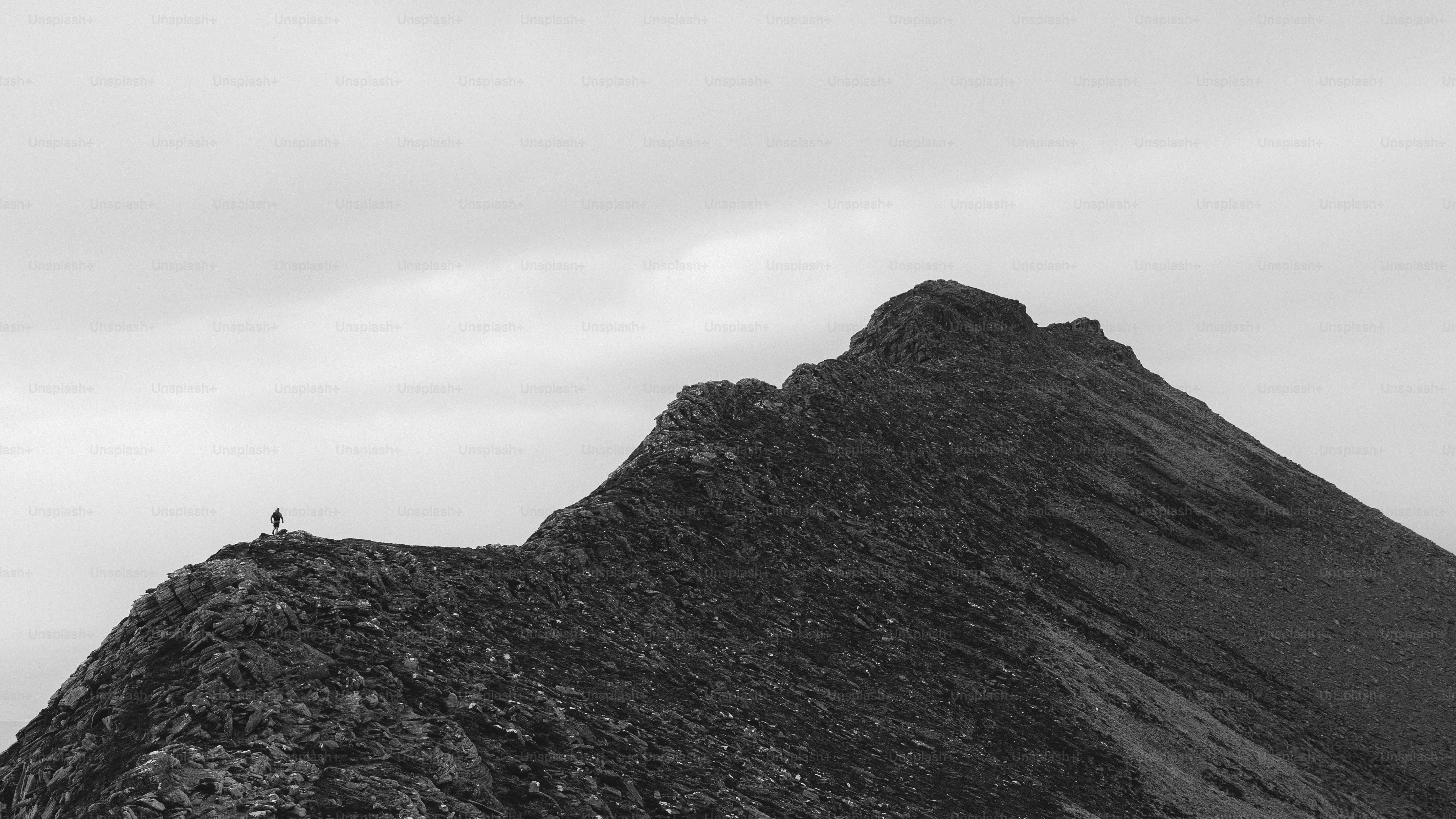 A person stands atop a mountain peak.