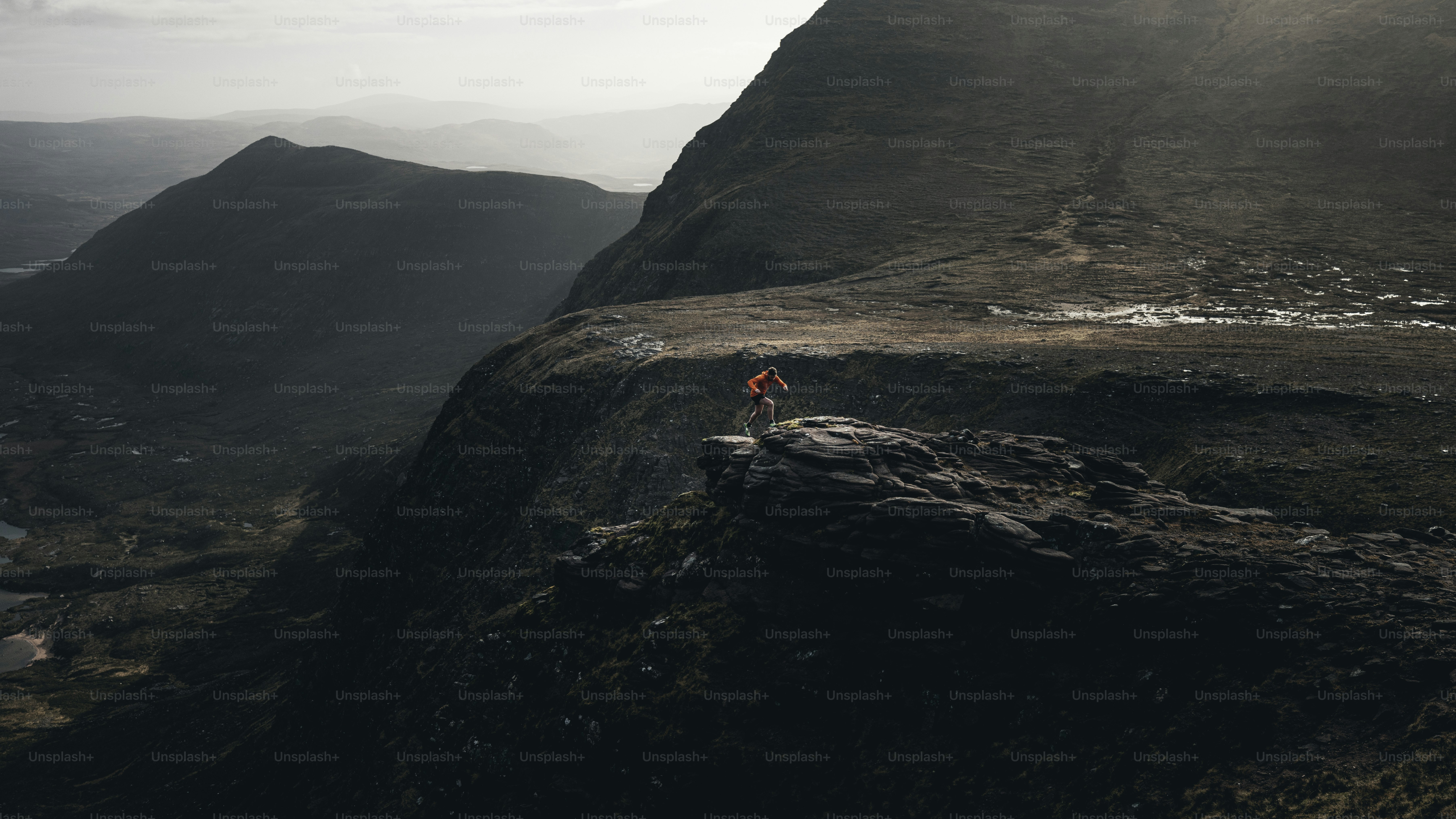 A person stands on a rocky cliff.