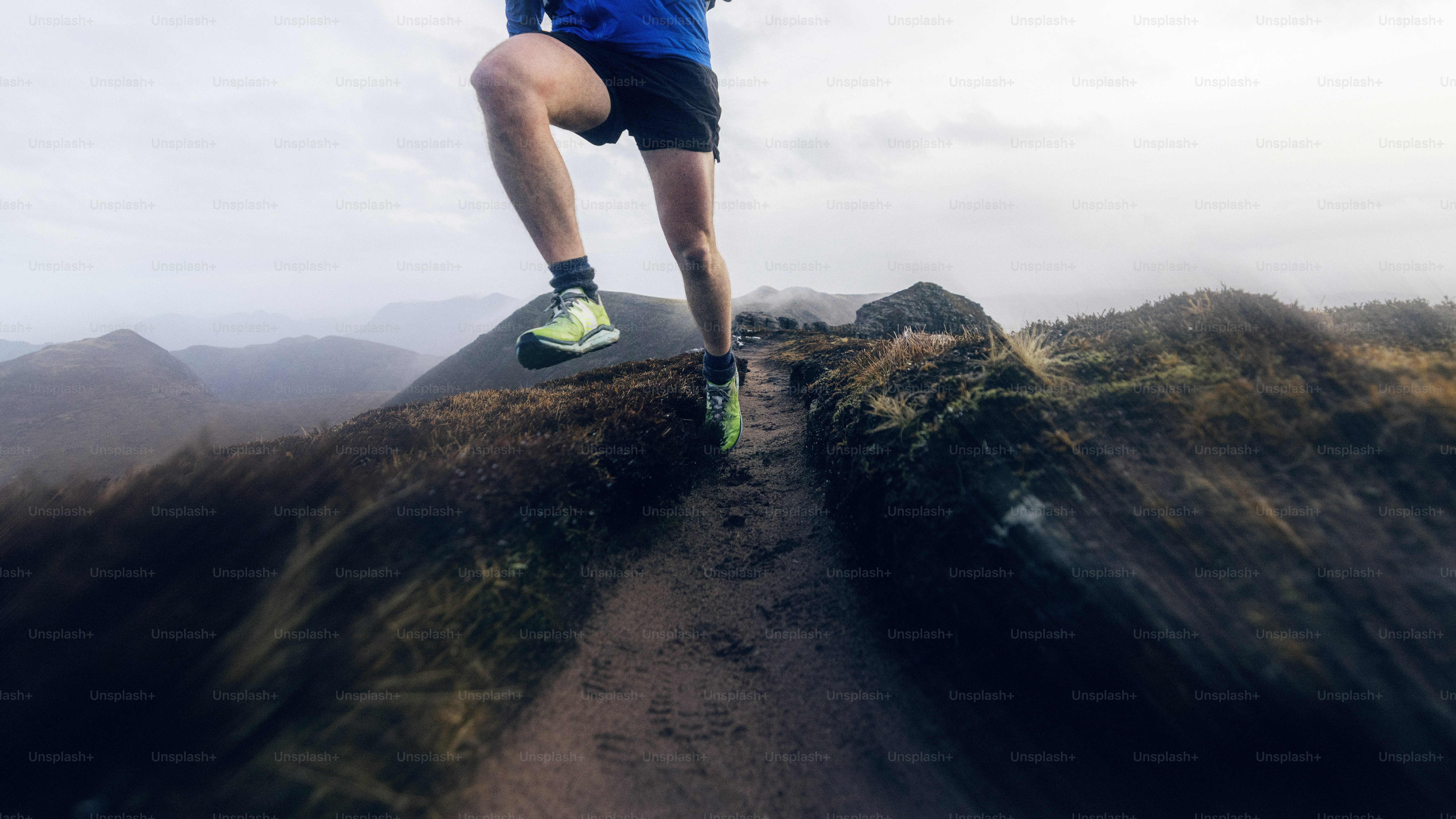 Runner sprints on a narrow mountain trail.