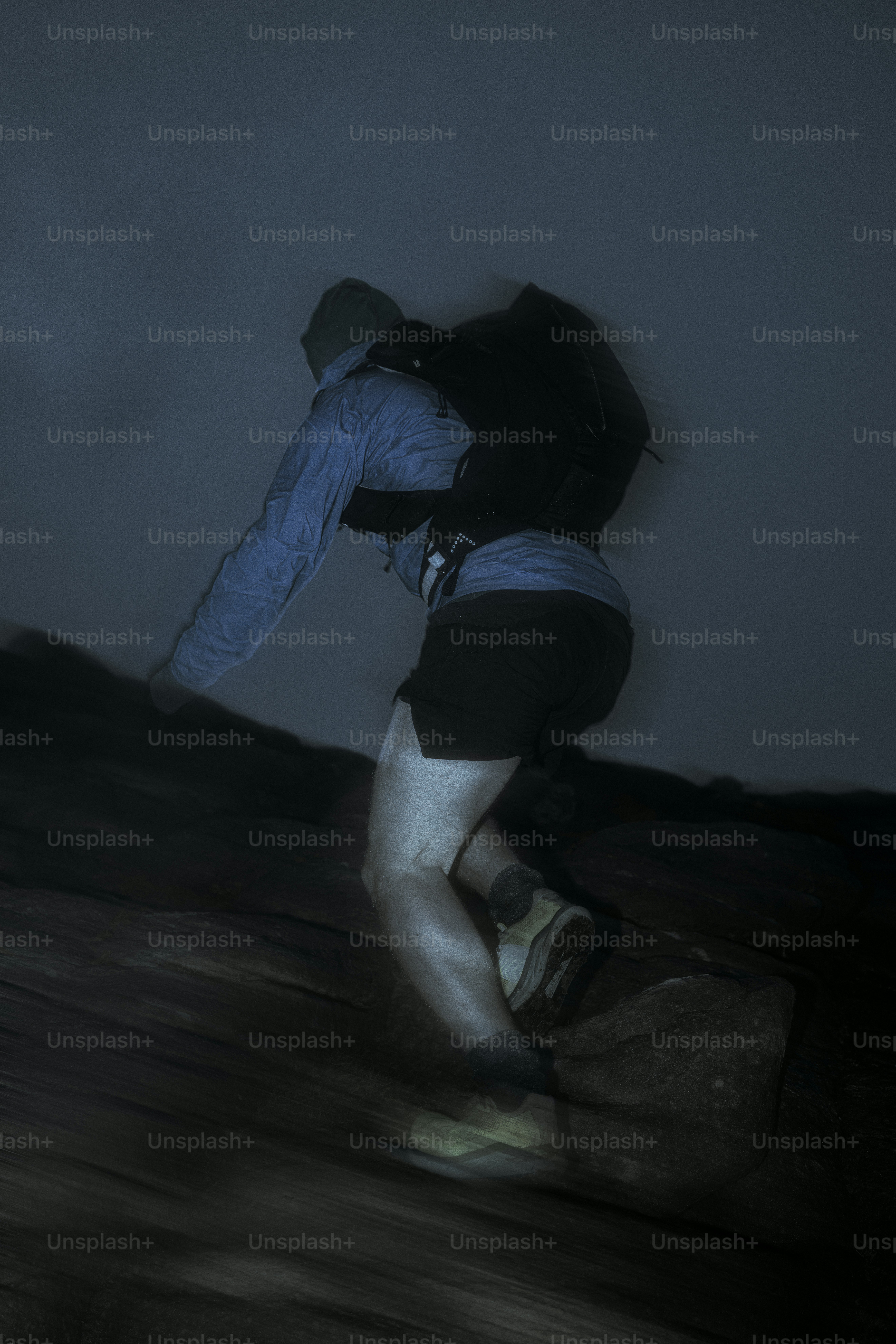 A person runs downhill at night.