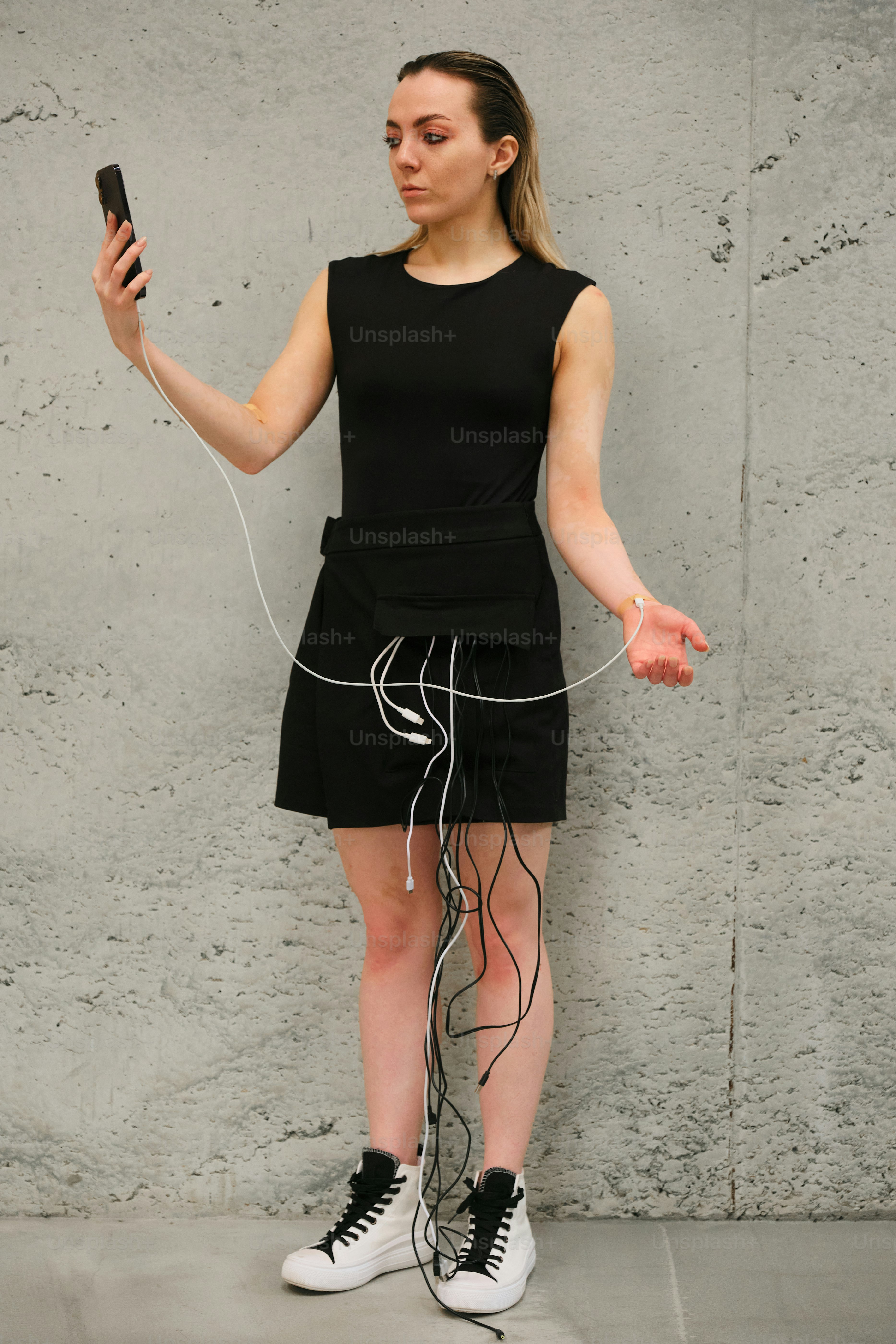 Woman is connected to a phone by many cords.