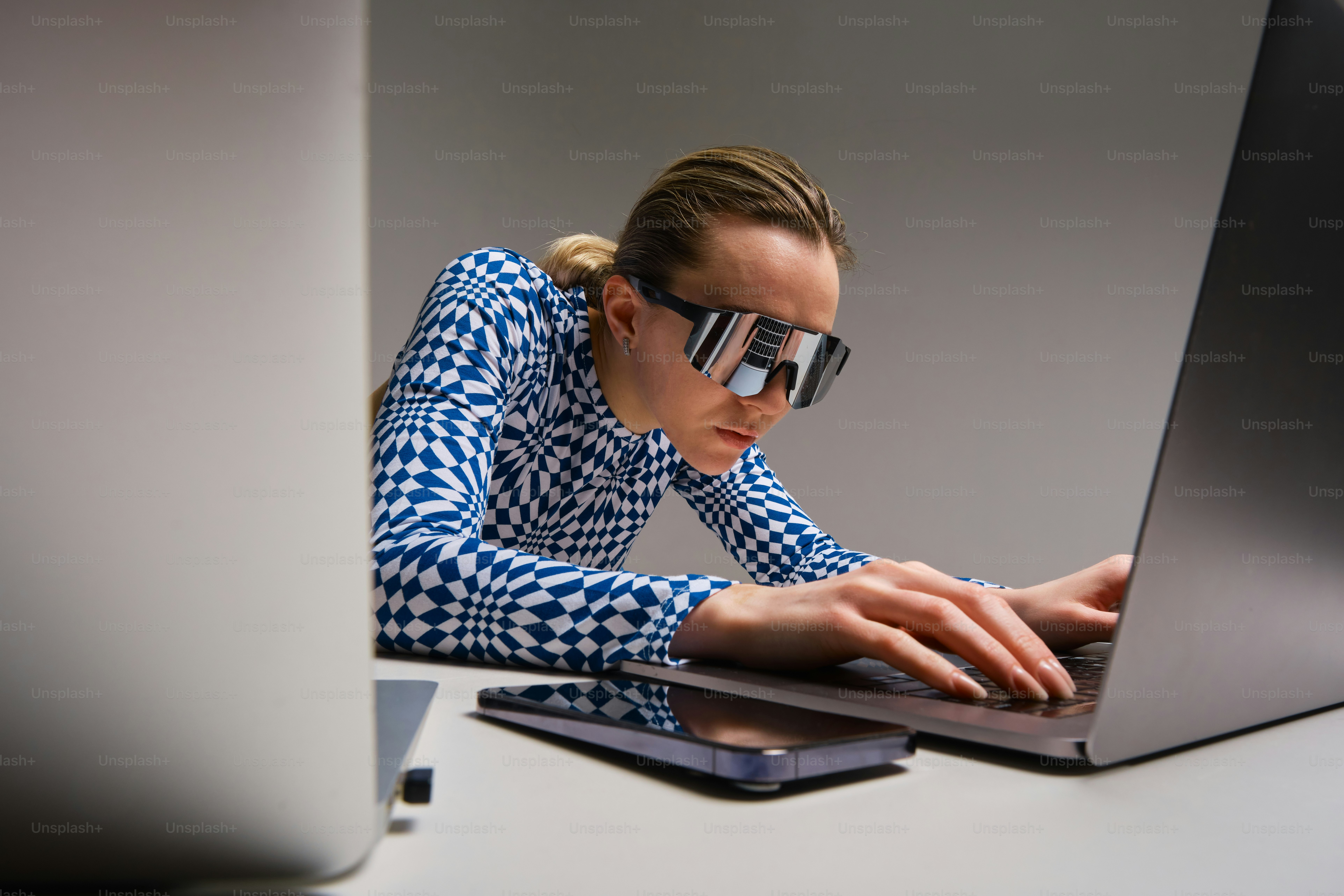 Femme aux lunettes futuristes travaillant sur un ordinateur portable