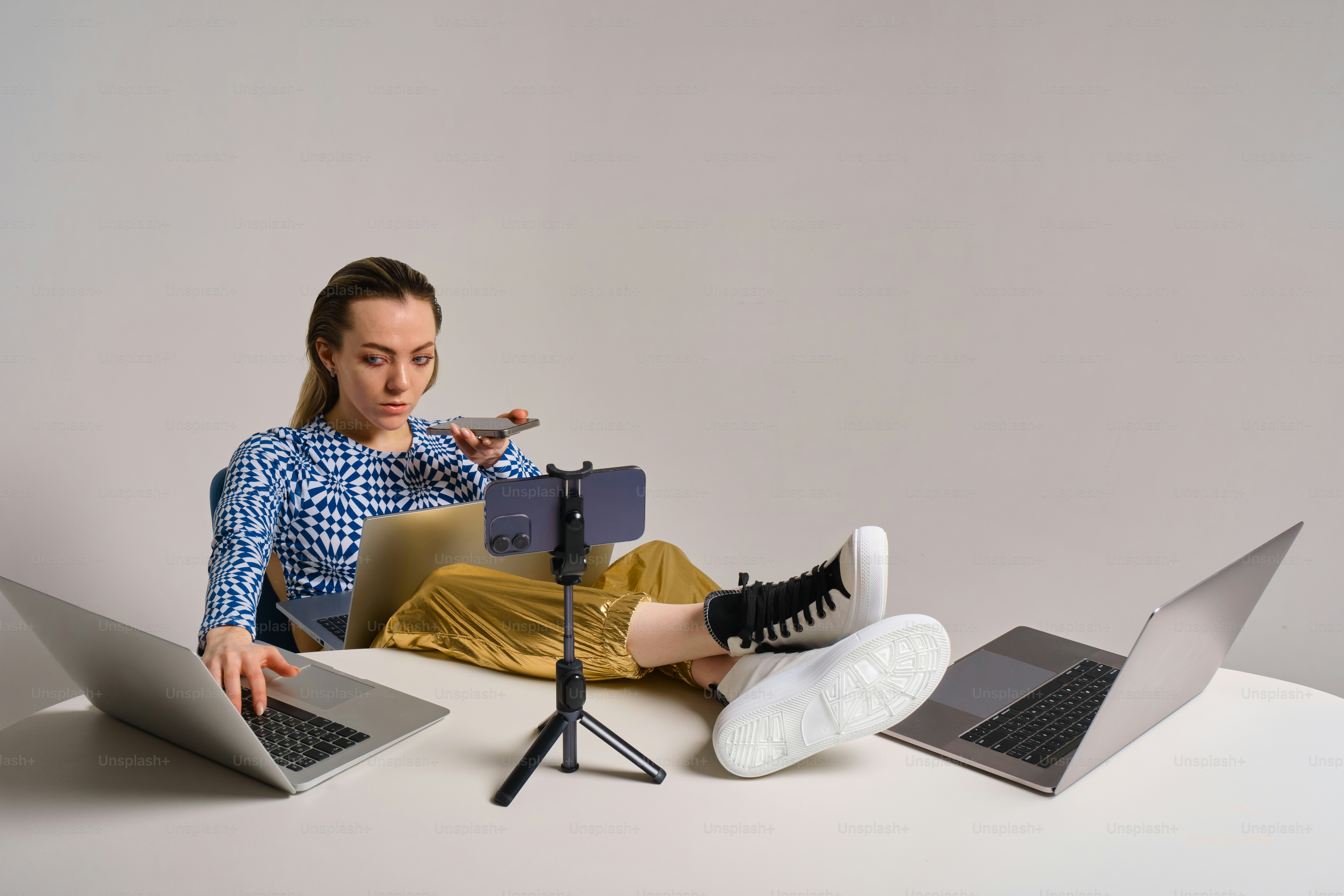 Woman multi-tasking on laptops with her feet up.