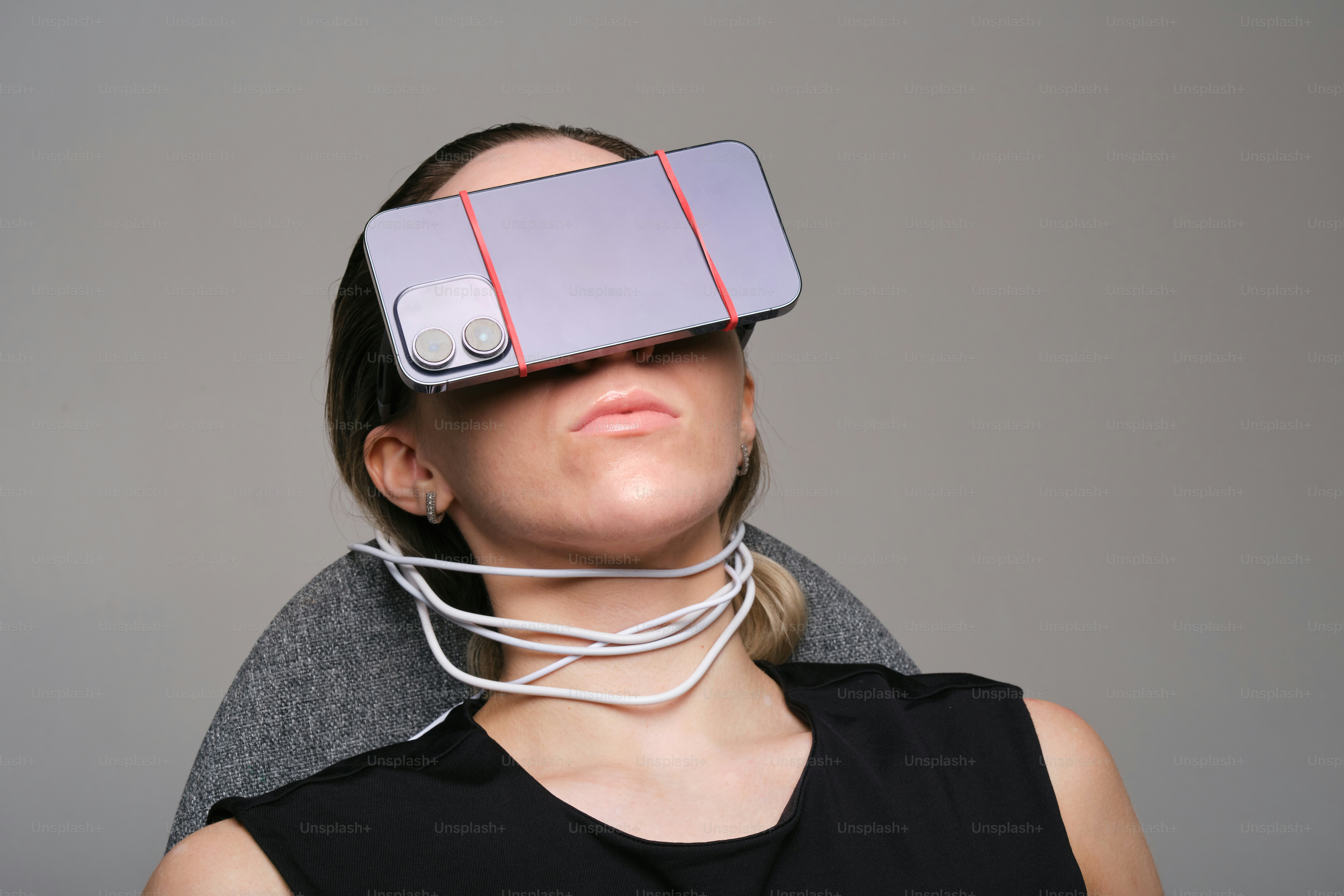 Woman has phone obscuring her eyes.