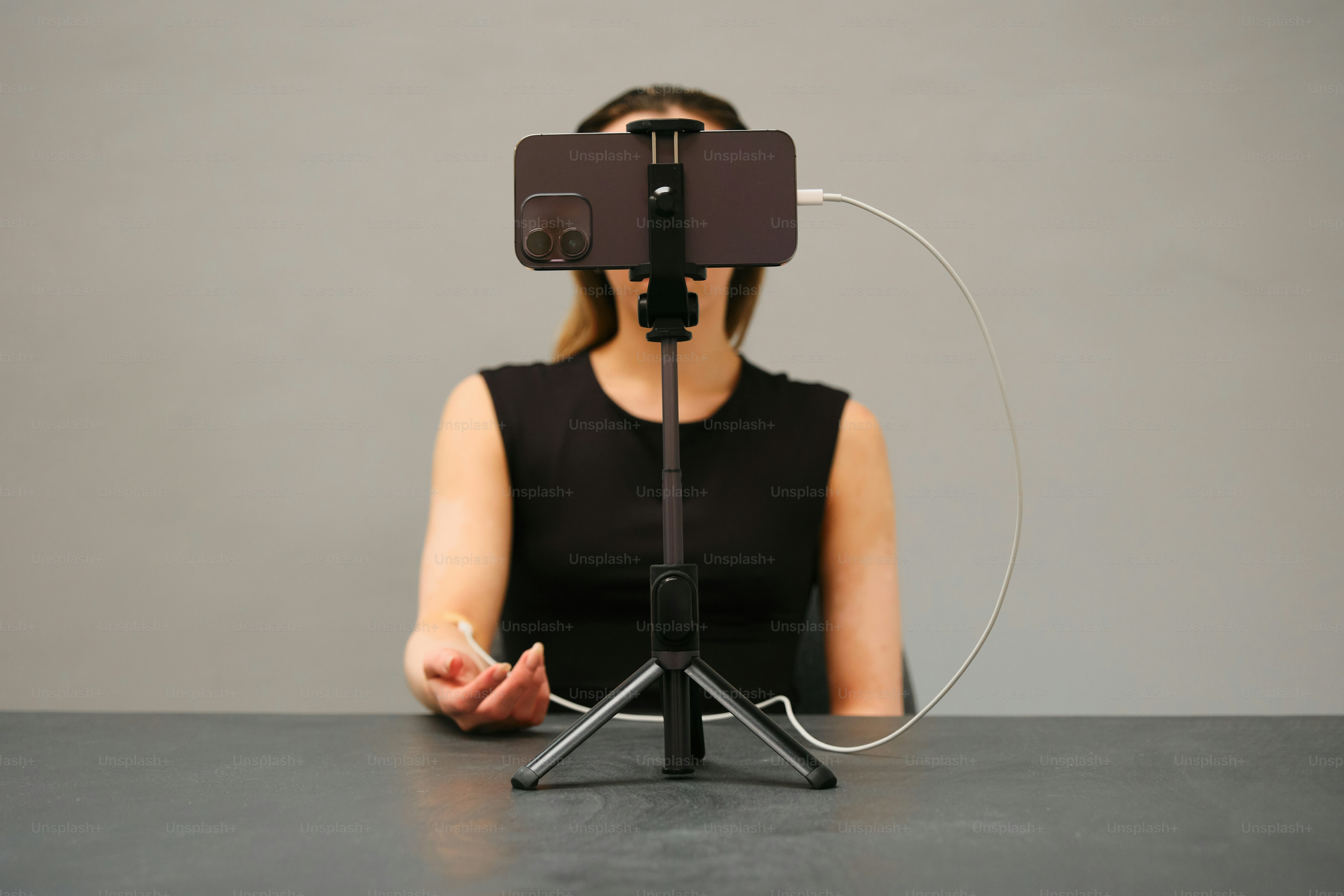 Woman filming with her phone on a tripod.