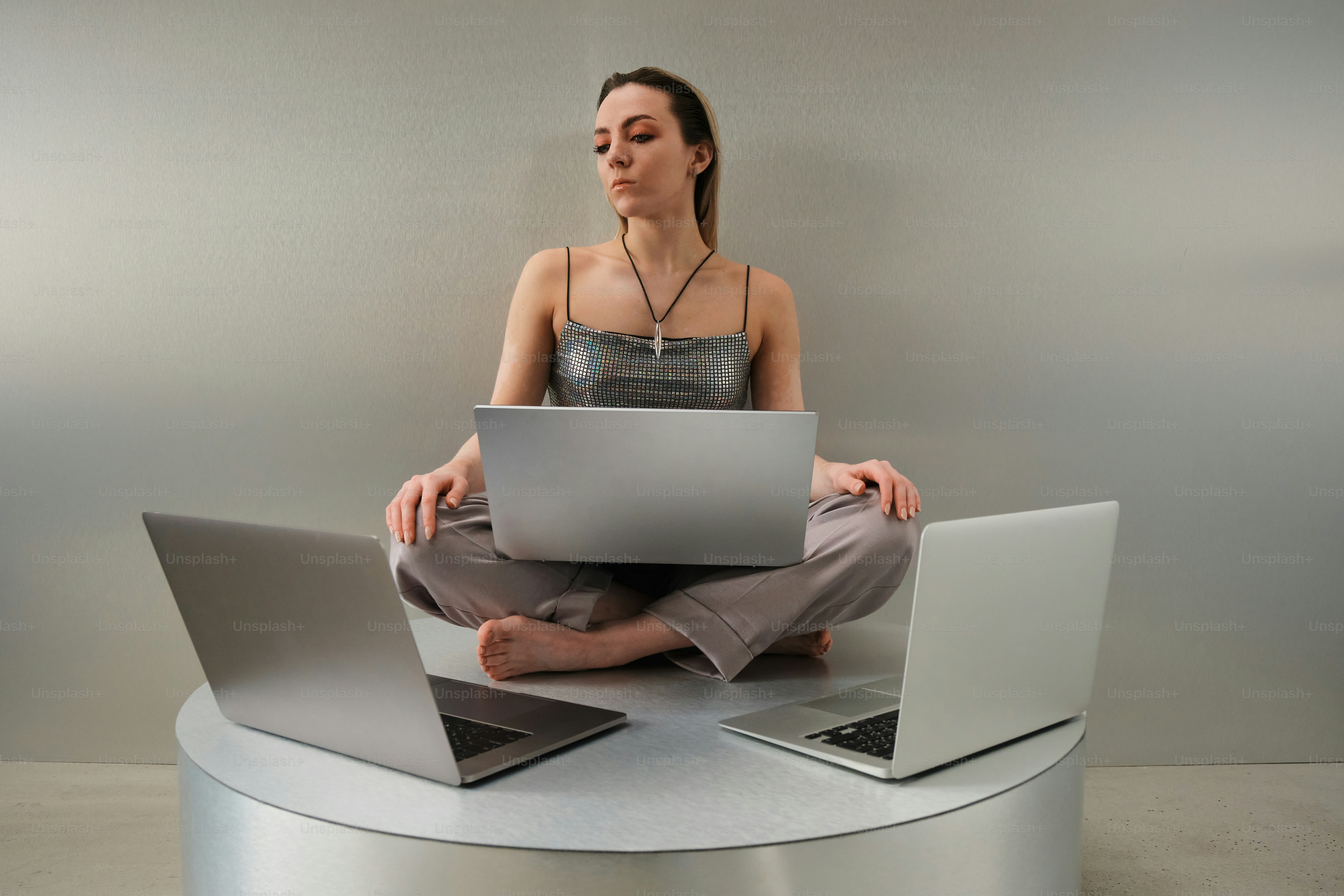 Woman works on multiple laptops simultaneously.