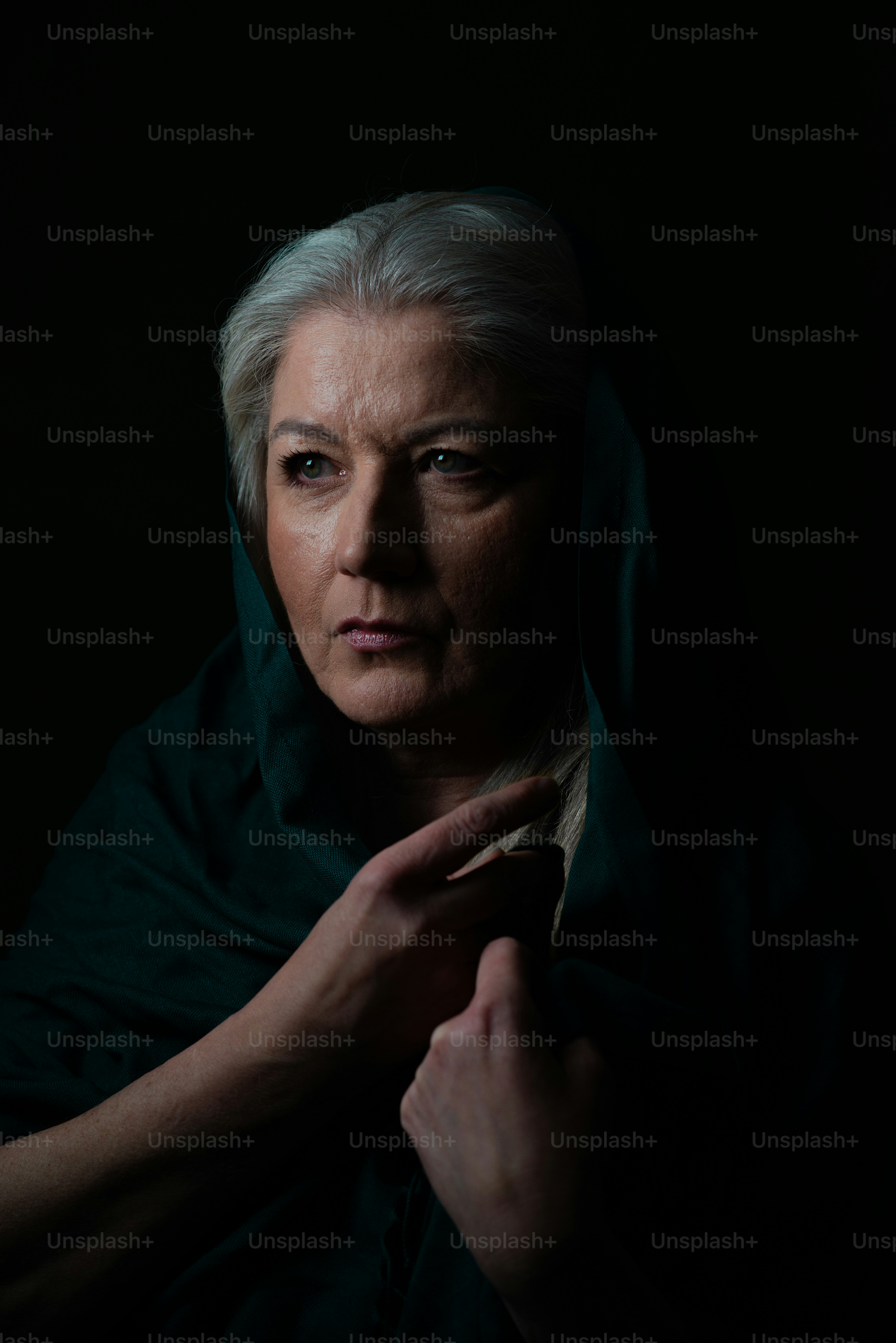 짙은 녹색으로 덮인 회색 머리를 가진 여자.