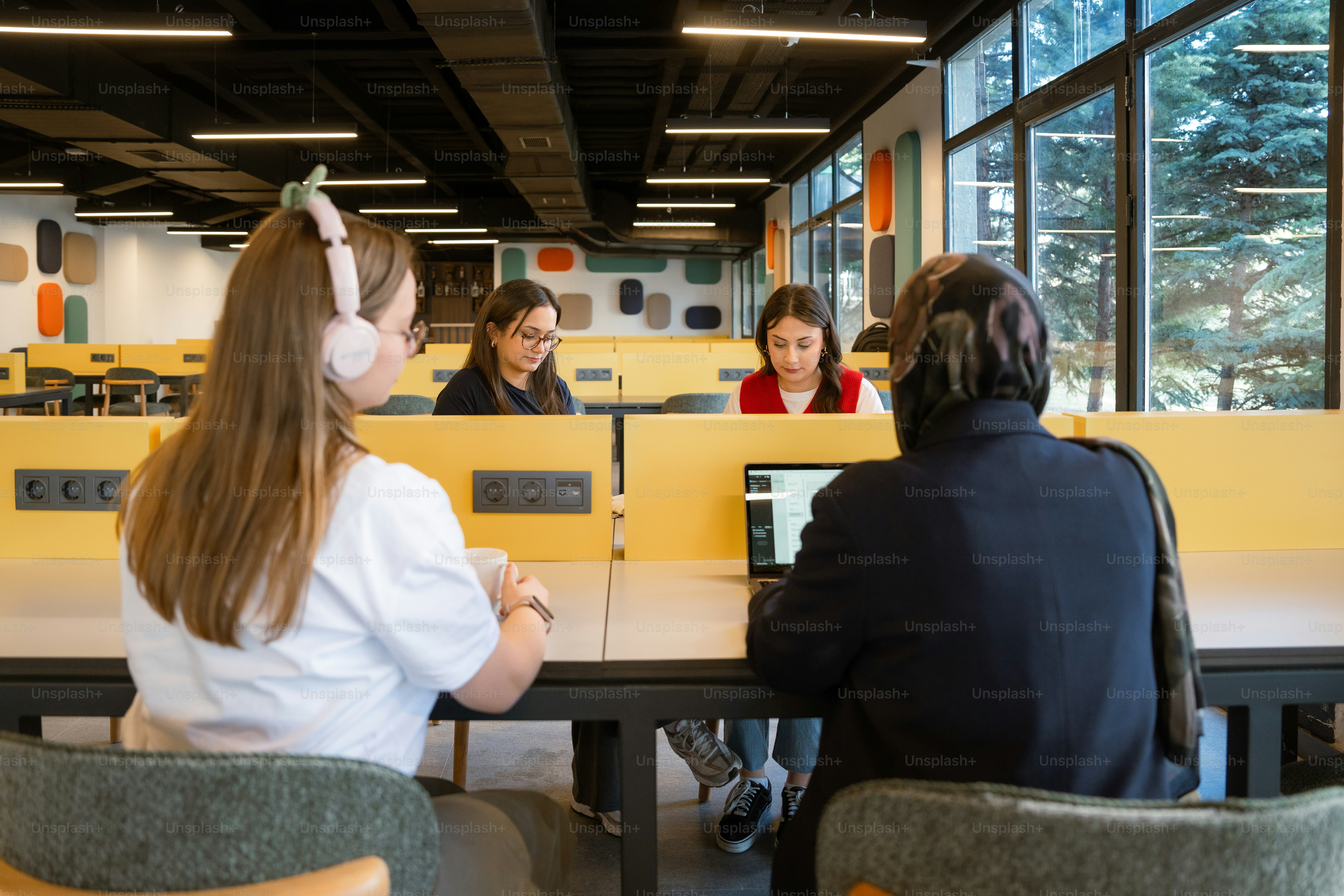 Students are working at a modern library desk.