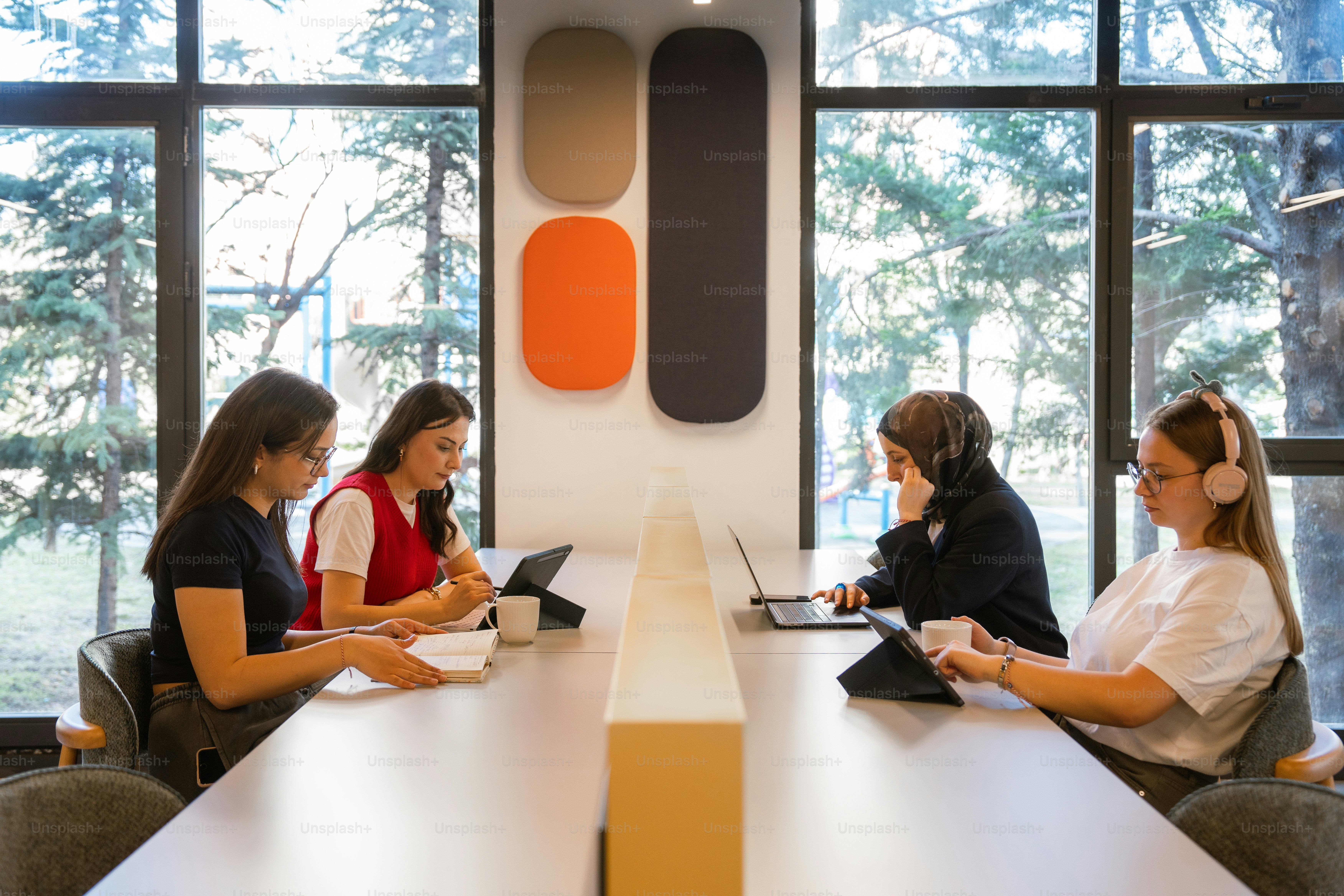Women are working on their devices in an office.