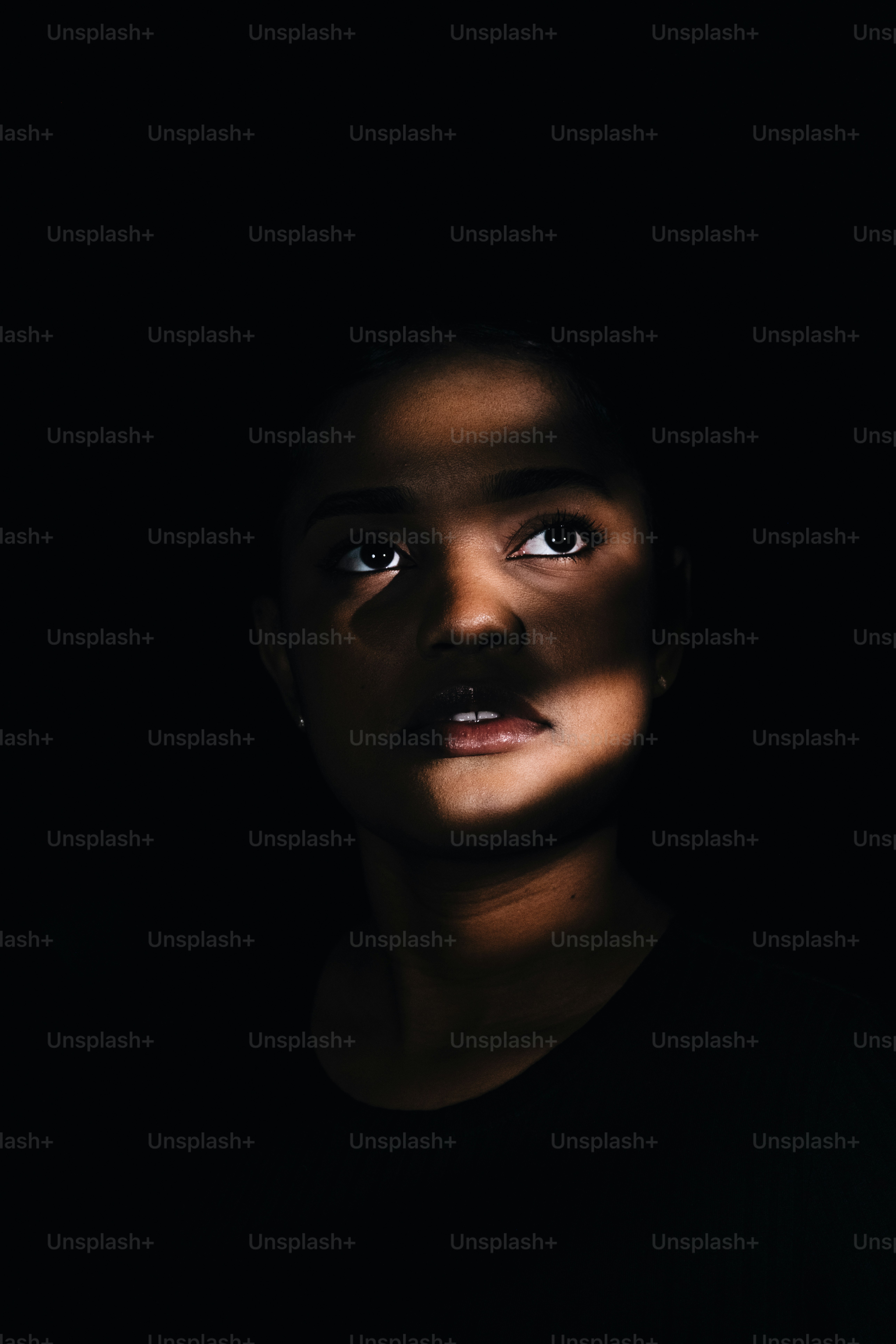 Une femme lève les yeux avec de la lumière sur le visage.