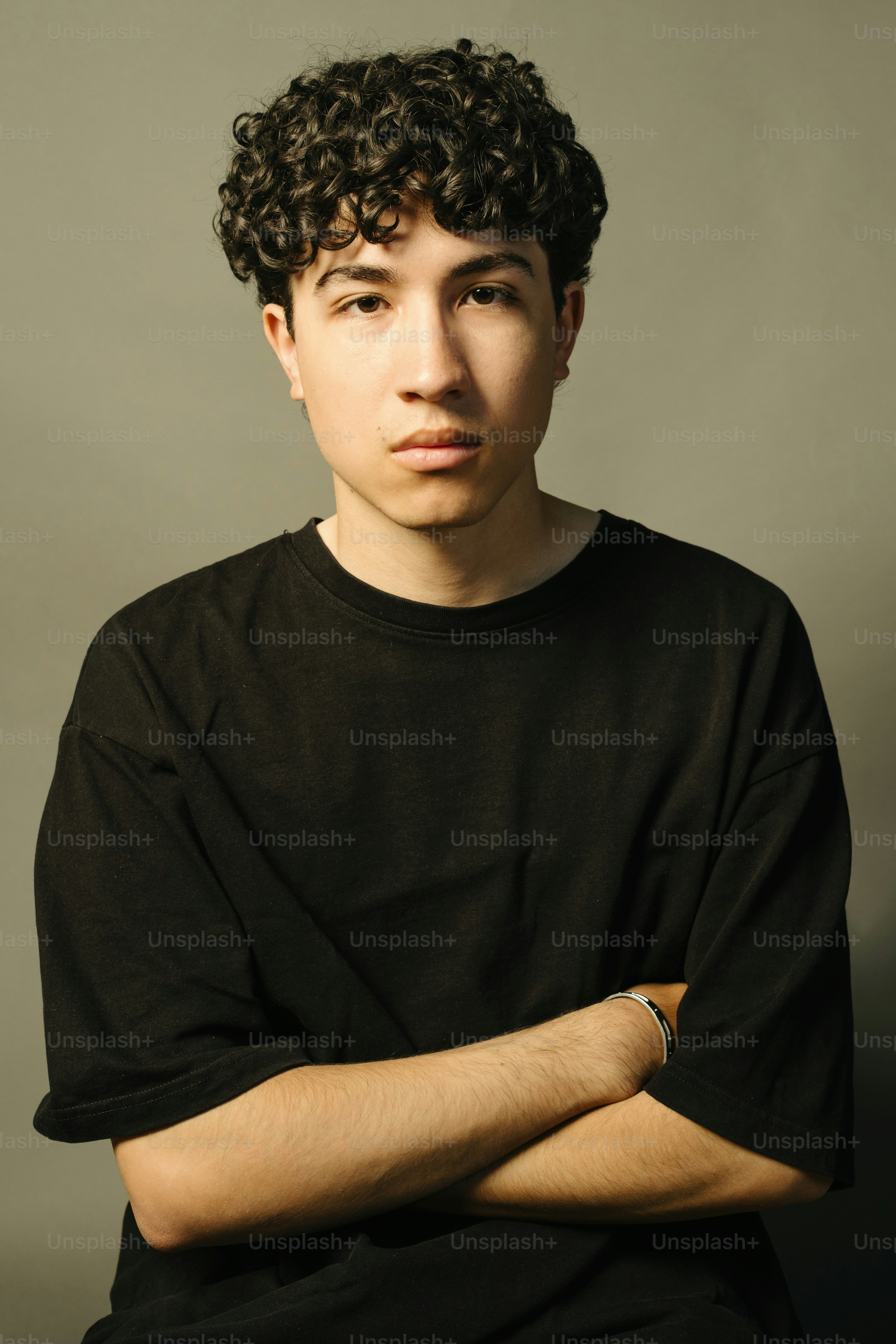 Young man poses with arms crossed.