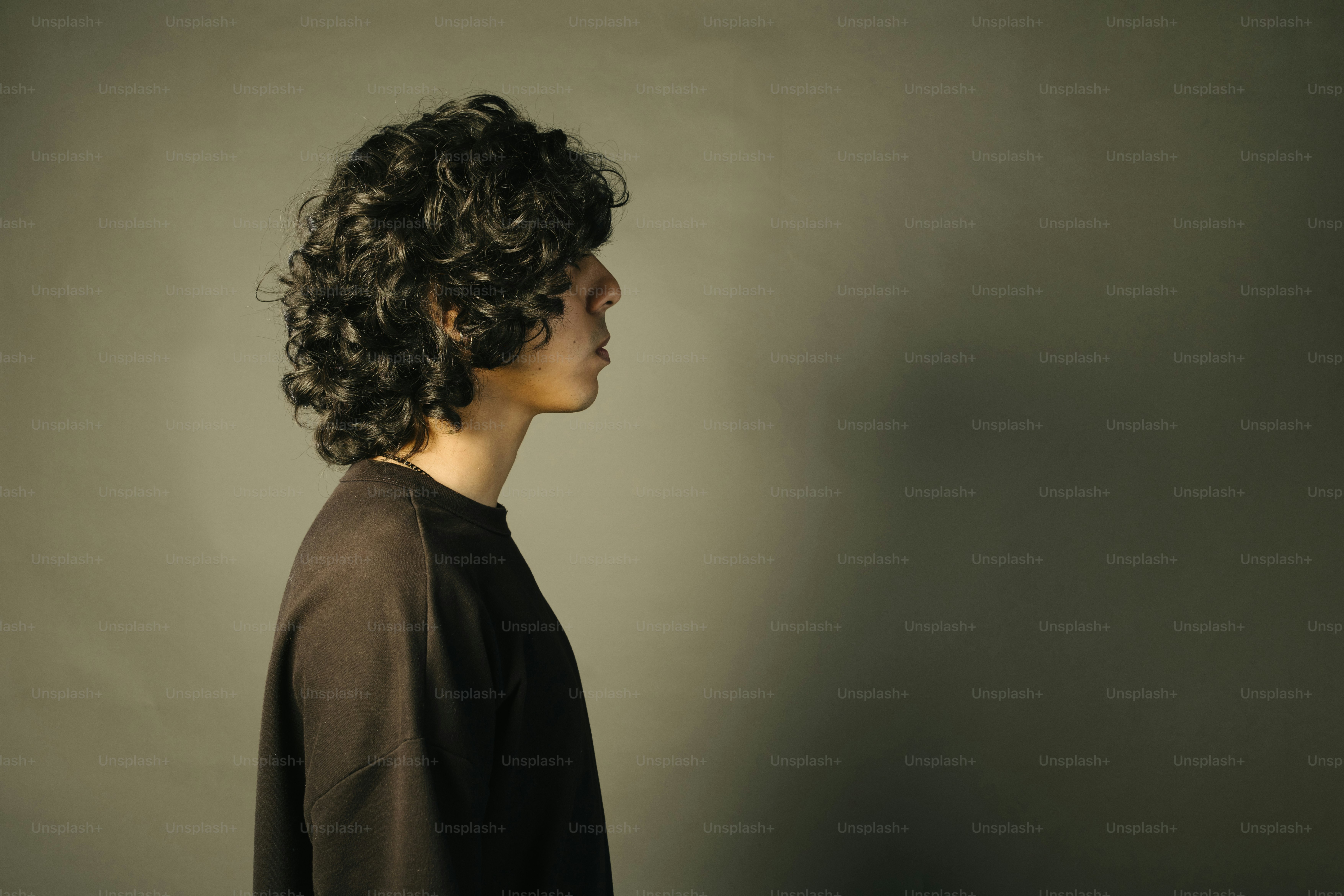 Person with curly hair in profile view