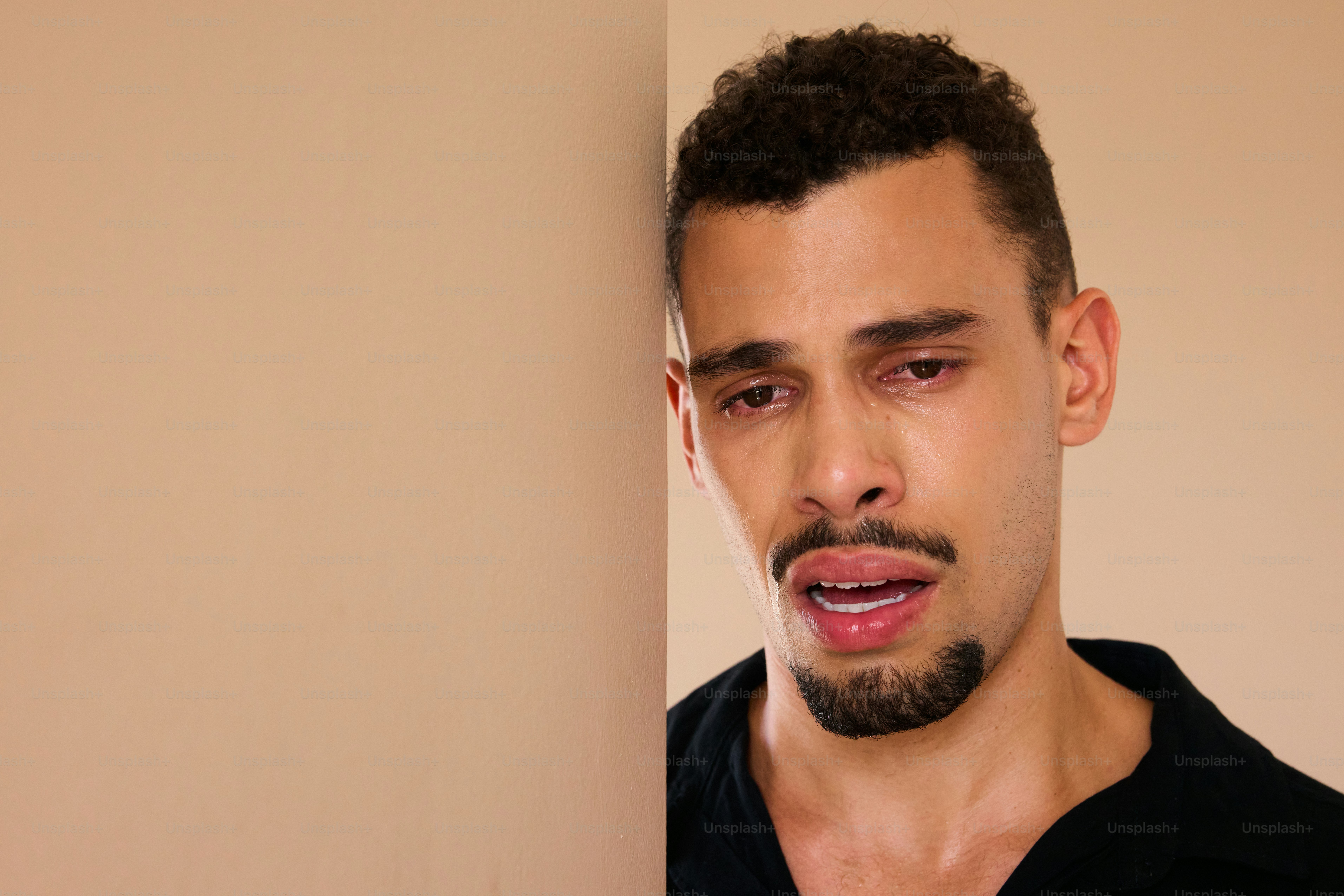 Un hombre apoyado en una pared parece molesto.