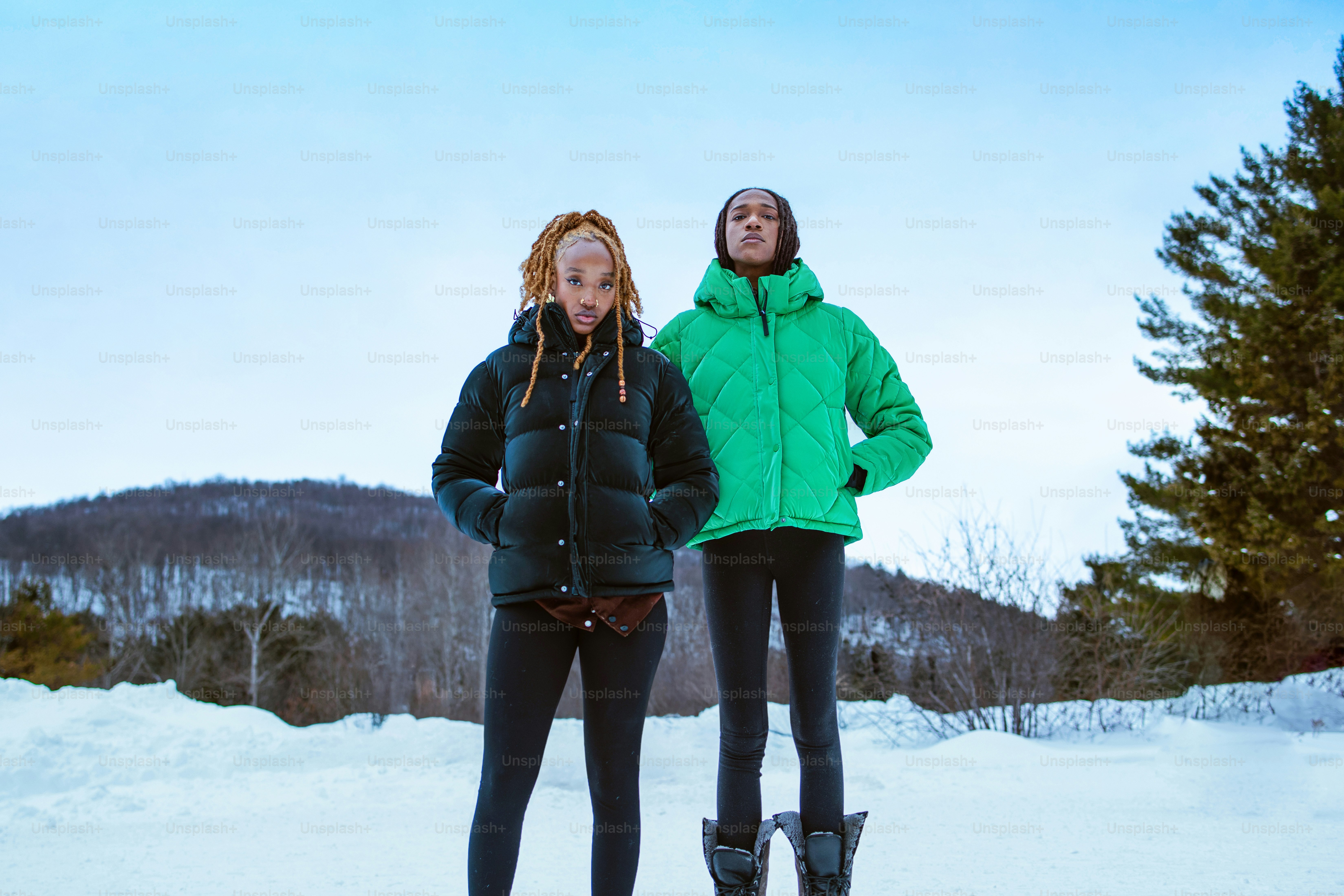 Two people pose in the snowy winter landscape.