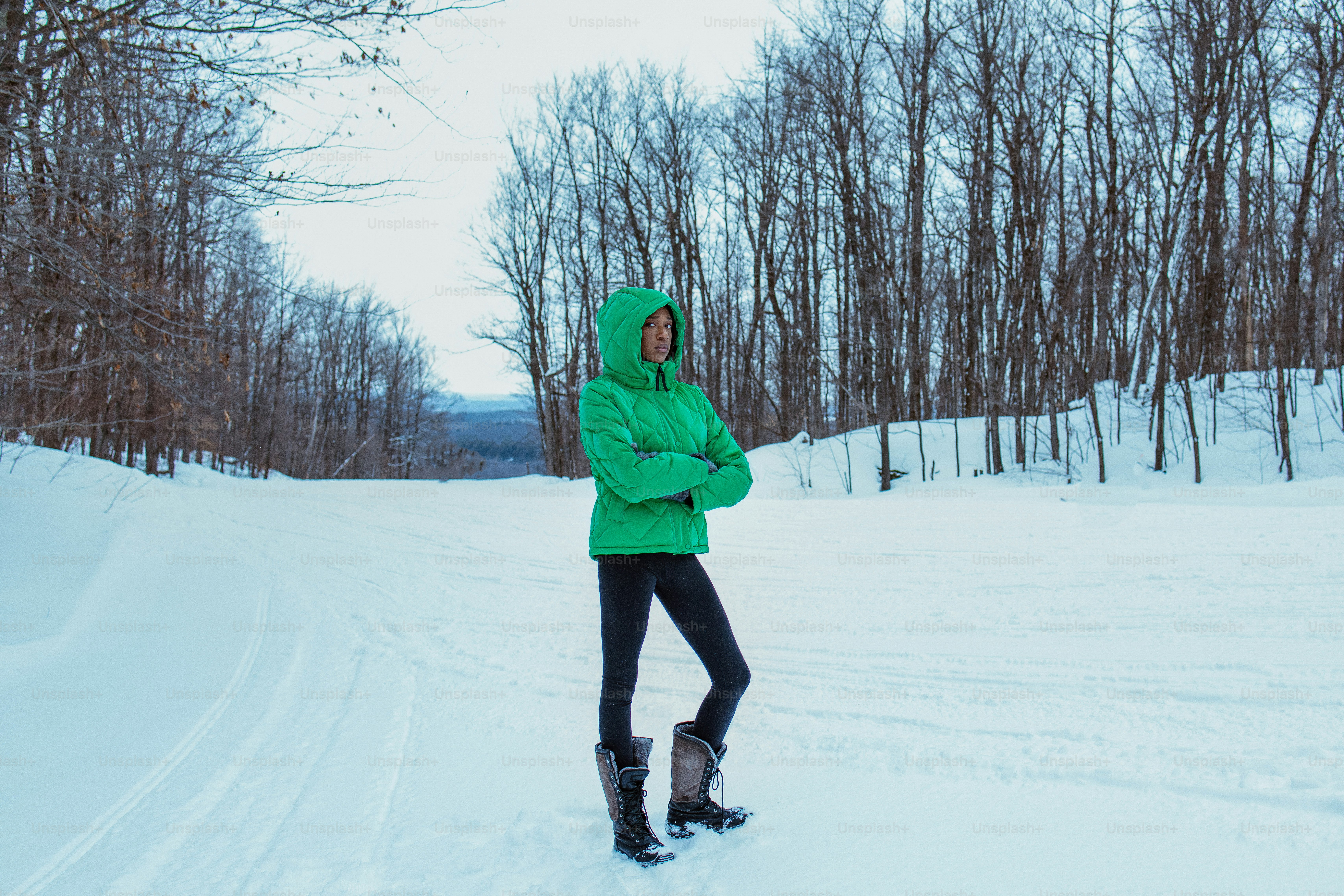A person stands in the snowy winter woods.