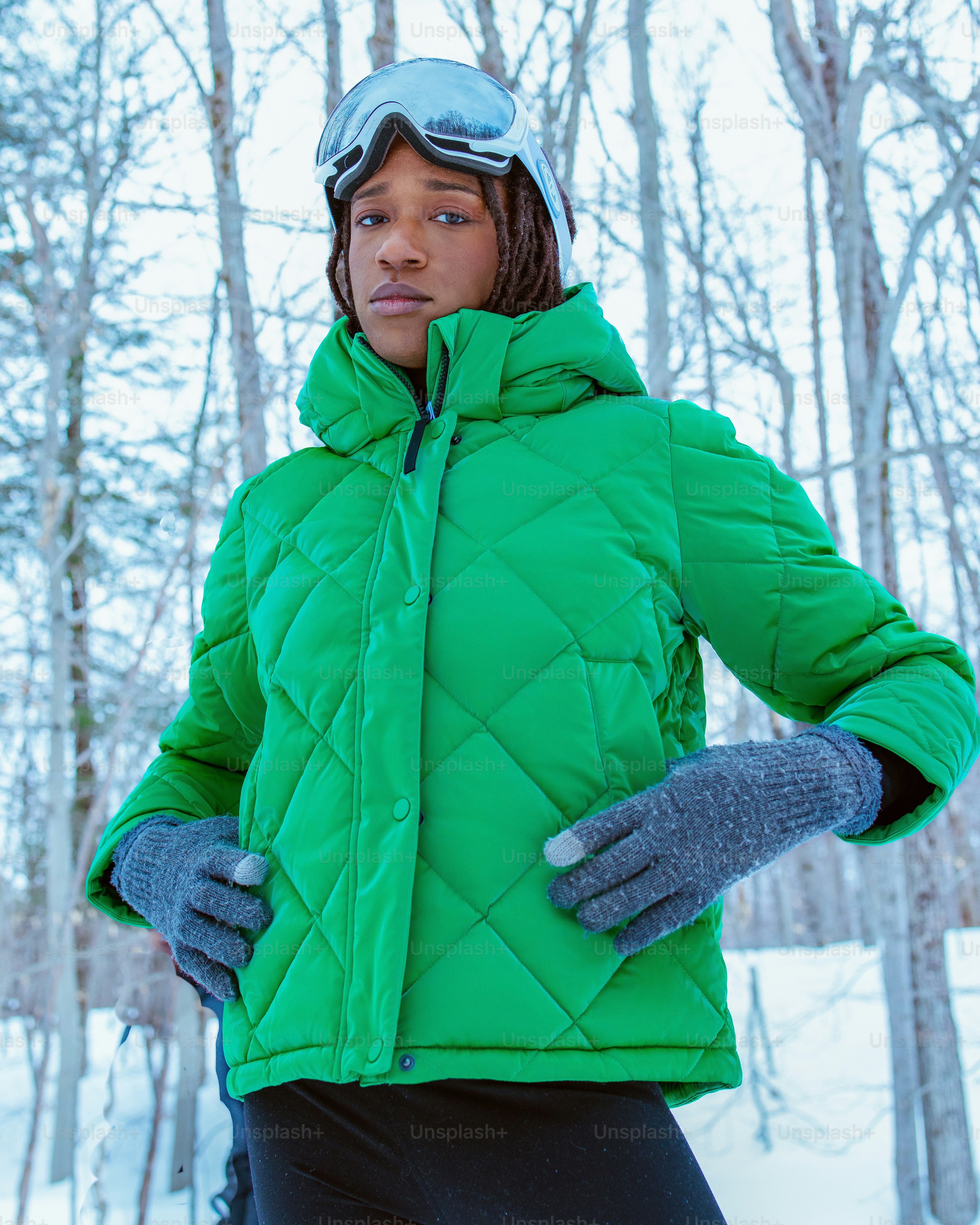 Person poses in winter gear in a snowy environment.