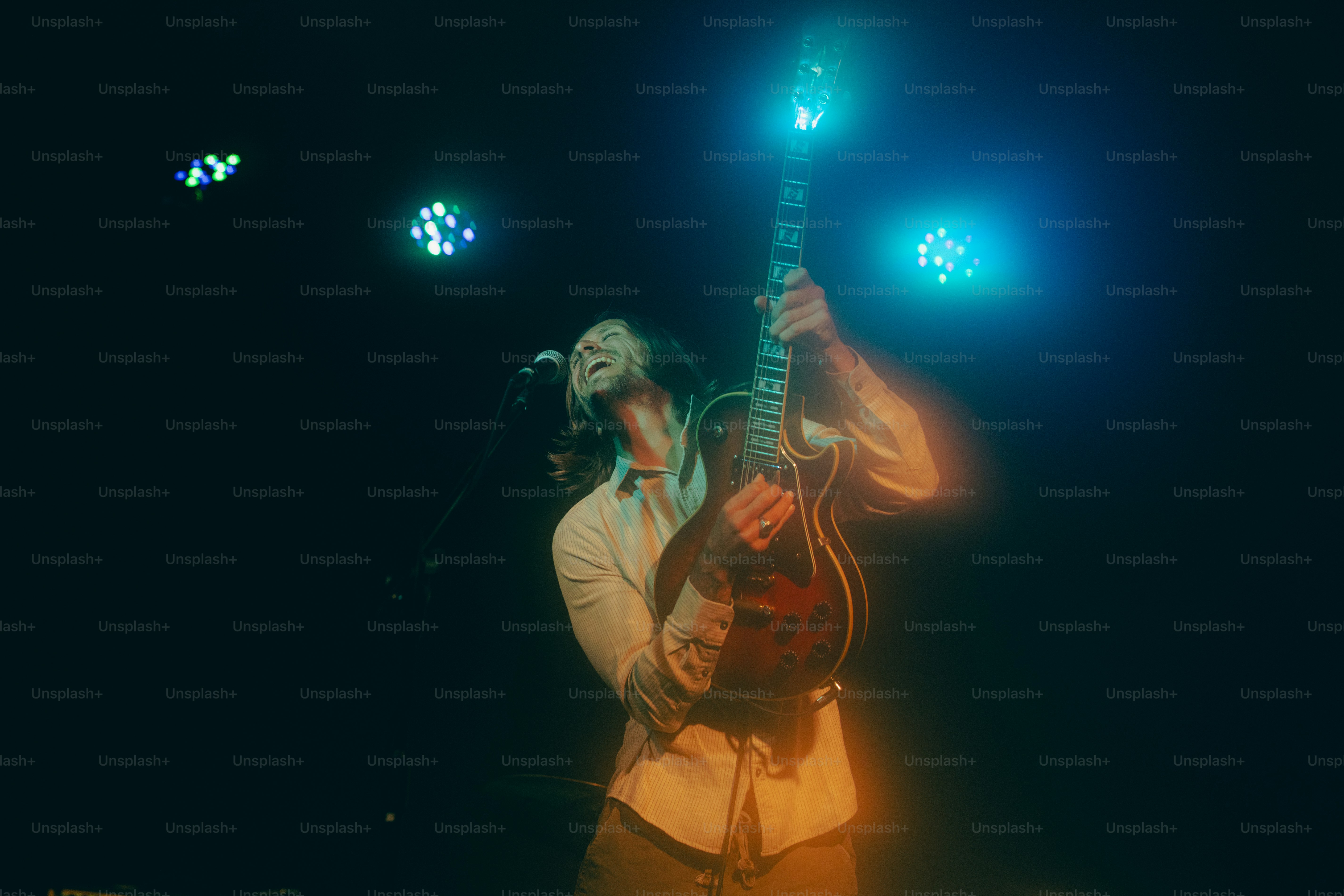 A musician performs on stage with a guitar.