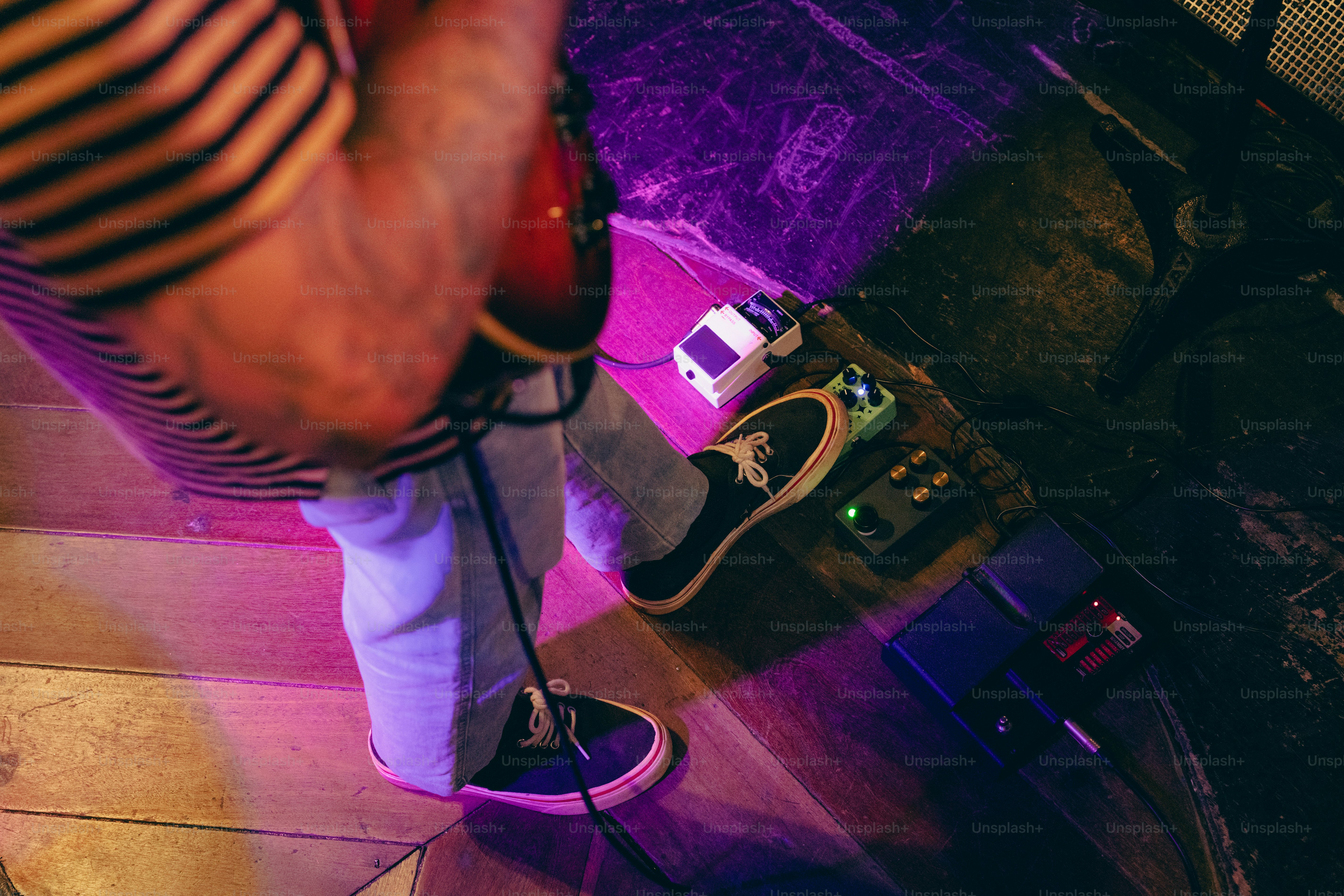 Bass player troubleshooting noisy bass pedals on a crowded pedalboard