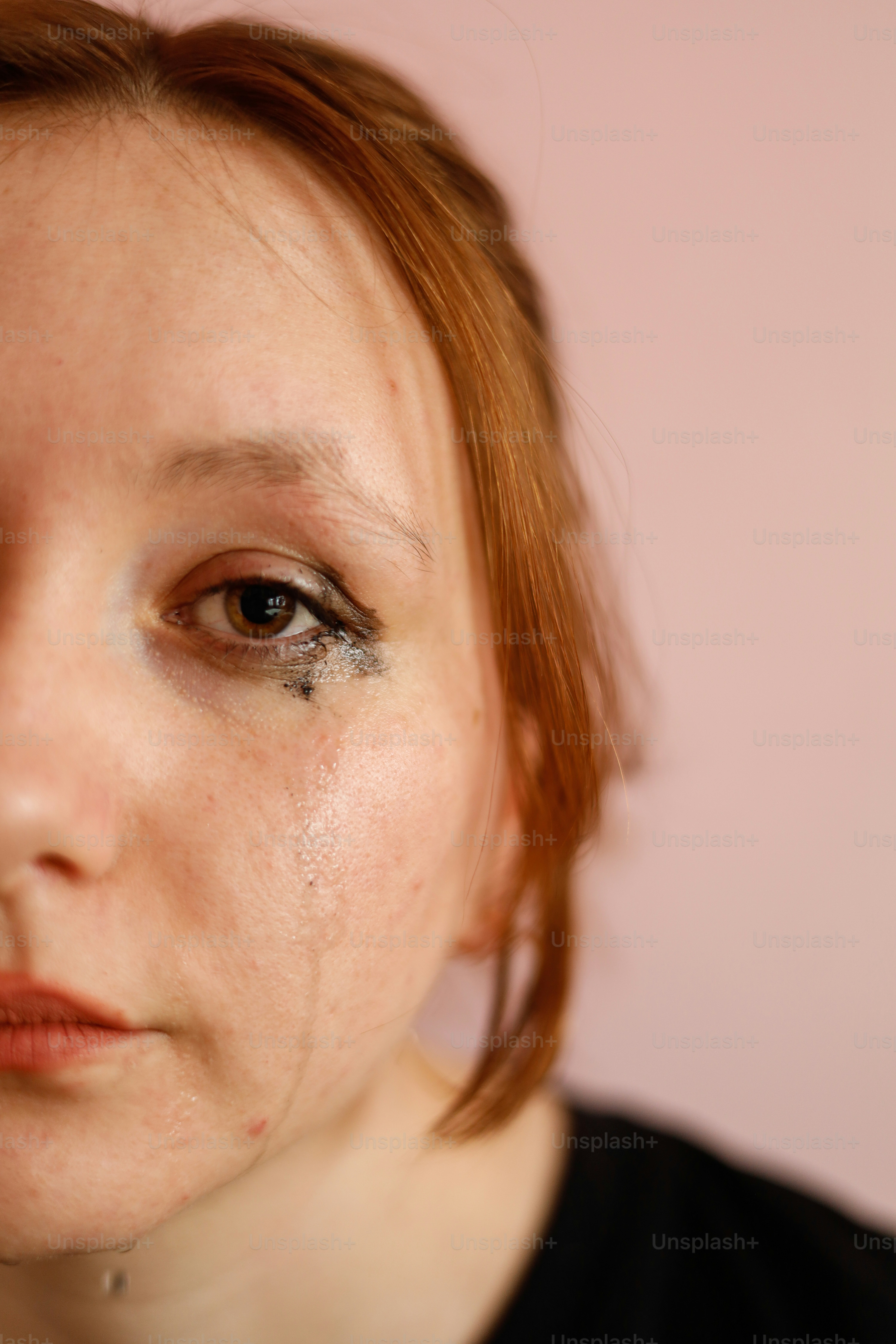 Mulher com maquiagem manchada, chorando.