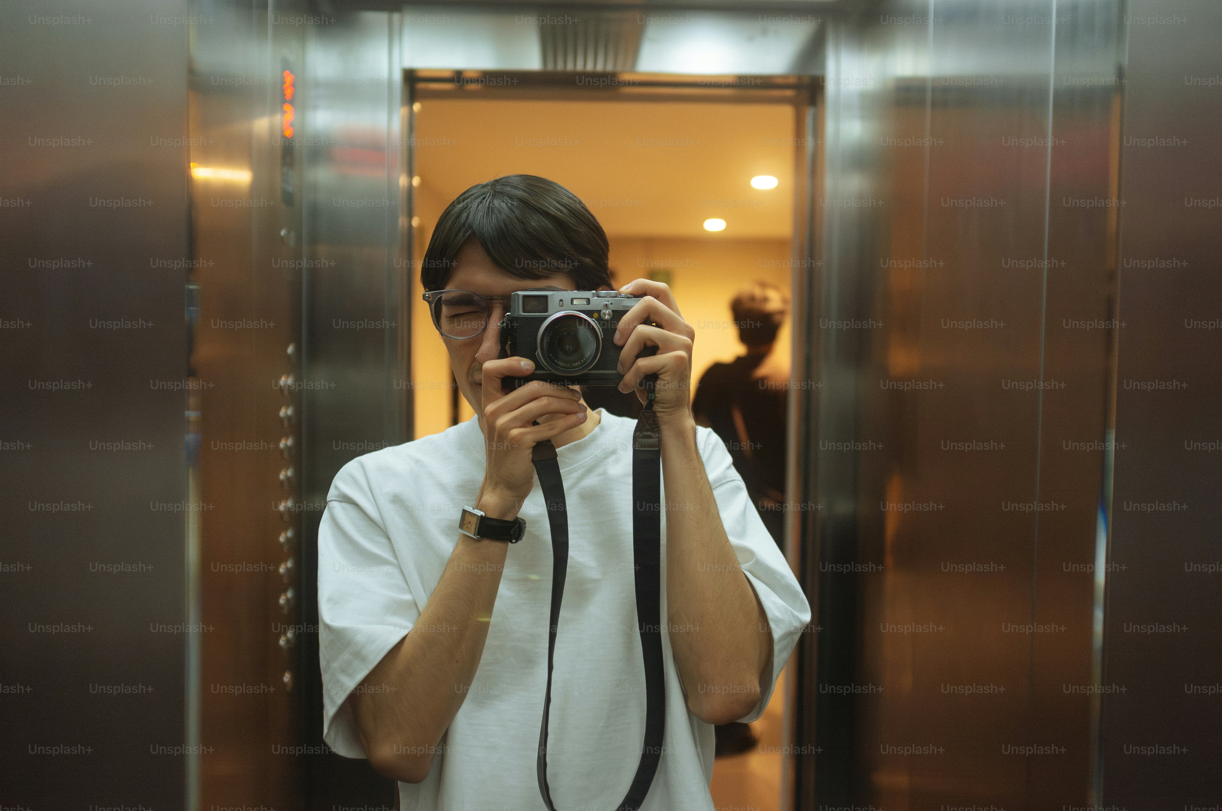 Mann macht ein Foto von sich in einem Aufzug.