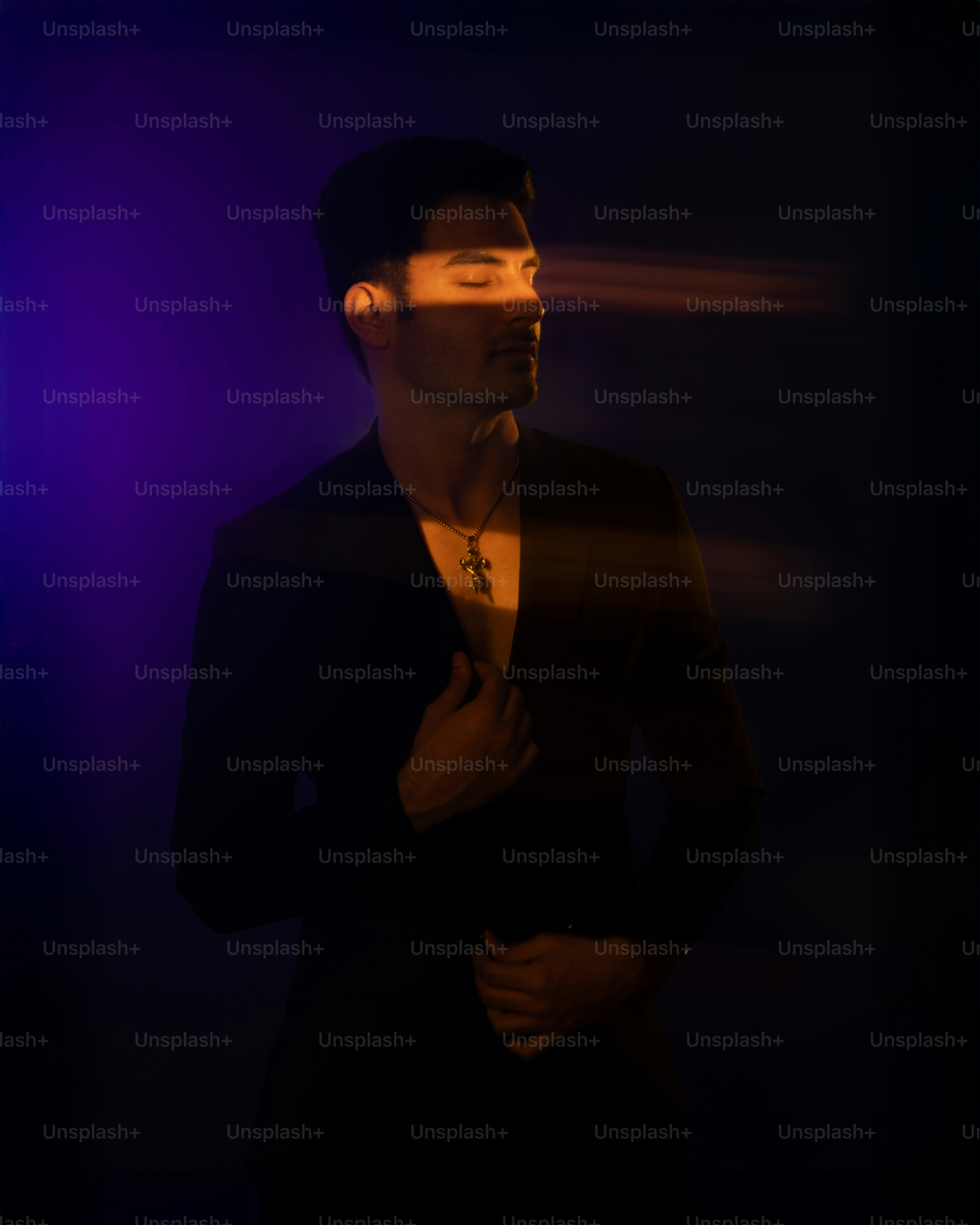 Un hombre elegante posa con una iluminación dramática.